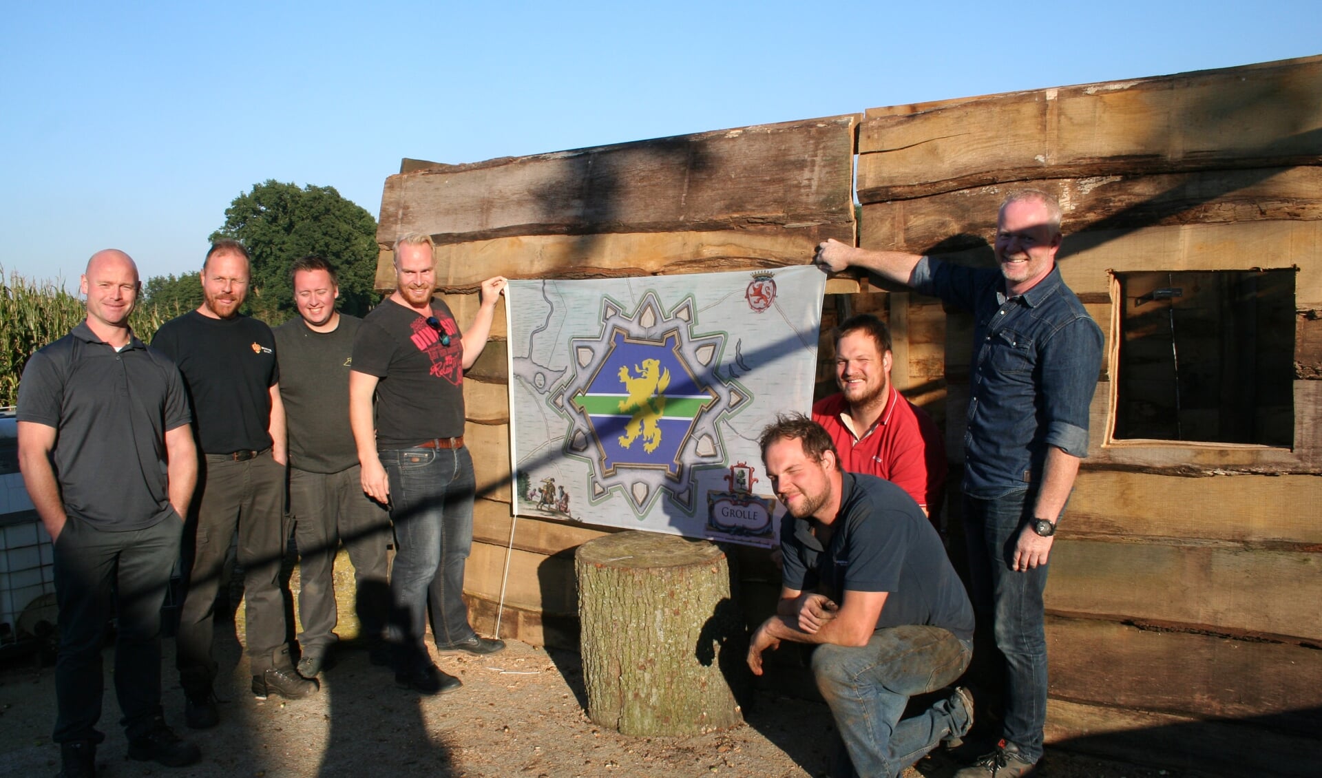 De heren bij de jagershut. De vlag is ontworpen door Sander van Zon (links naast de vlag). Foto: Kyra Broshuis