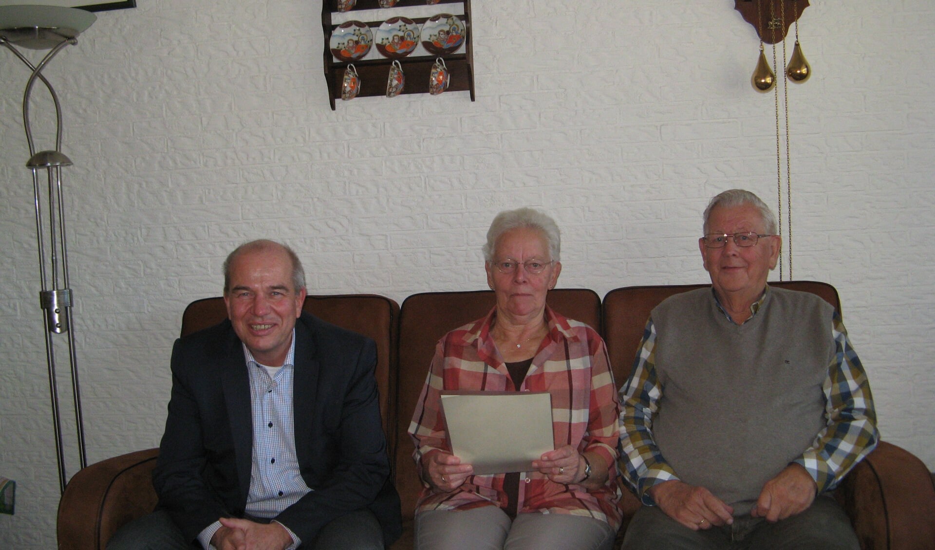  Jo en Henk Pardijs bekijken de kopie van hun huwelijksakte die wethouder Wim Aalderink afgelopen donderdag voor hen meebracht. Foto: Bart Kraan