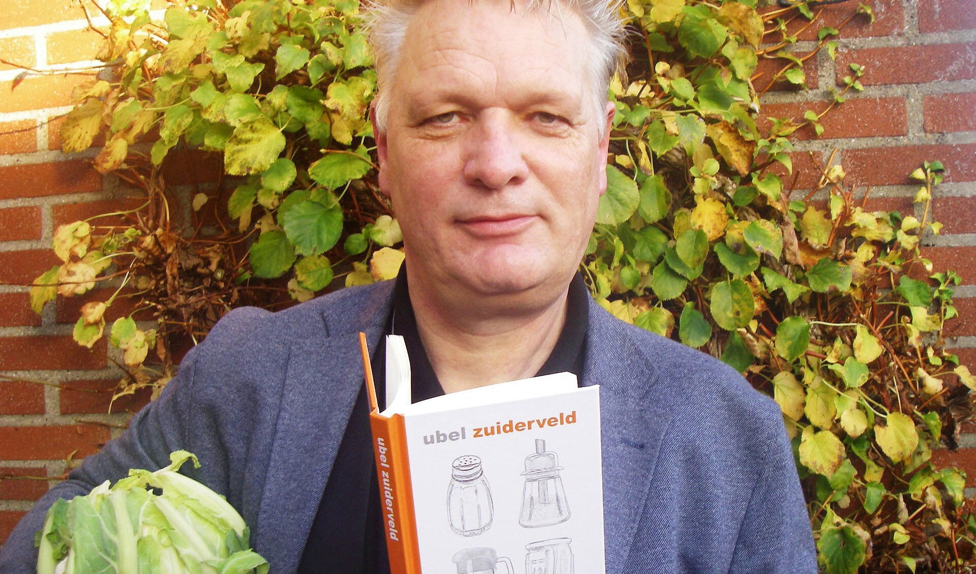 Ubel Zuiderveld met zijn nieuwe boek, en - passend - ook met iets eetbaars. Foto: Bernhard Harfsterkamp