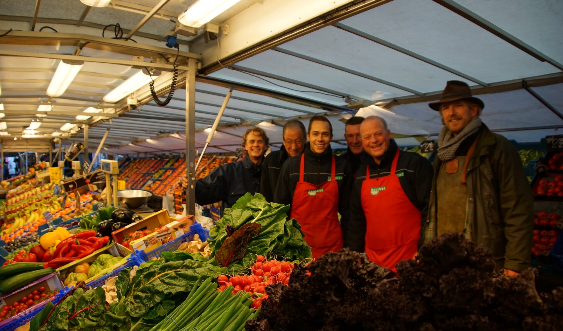 Arjan Huusken (tweede rechts) met zijn broer (r) en de medewerkers achter de marktkraam in Vorden. Foto: Bernadet te Velthuis