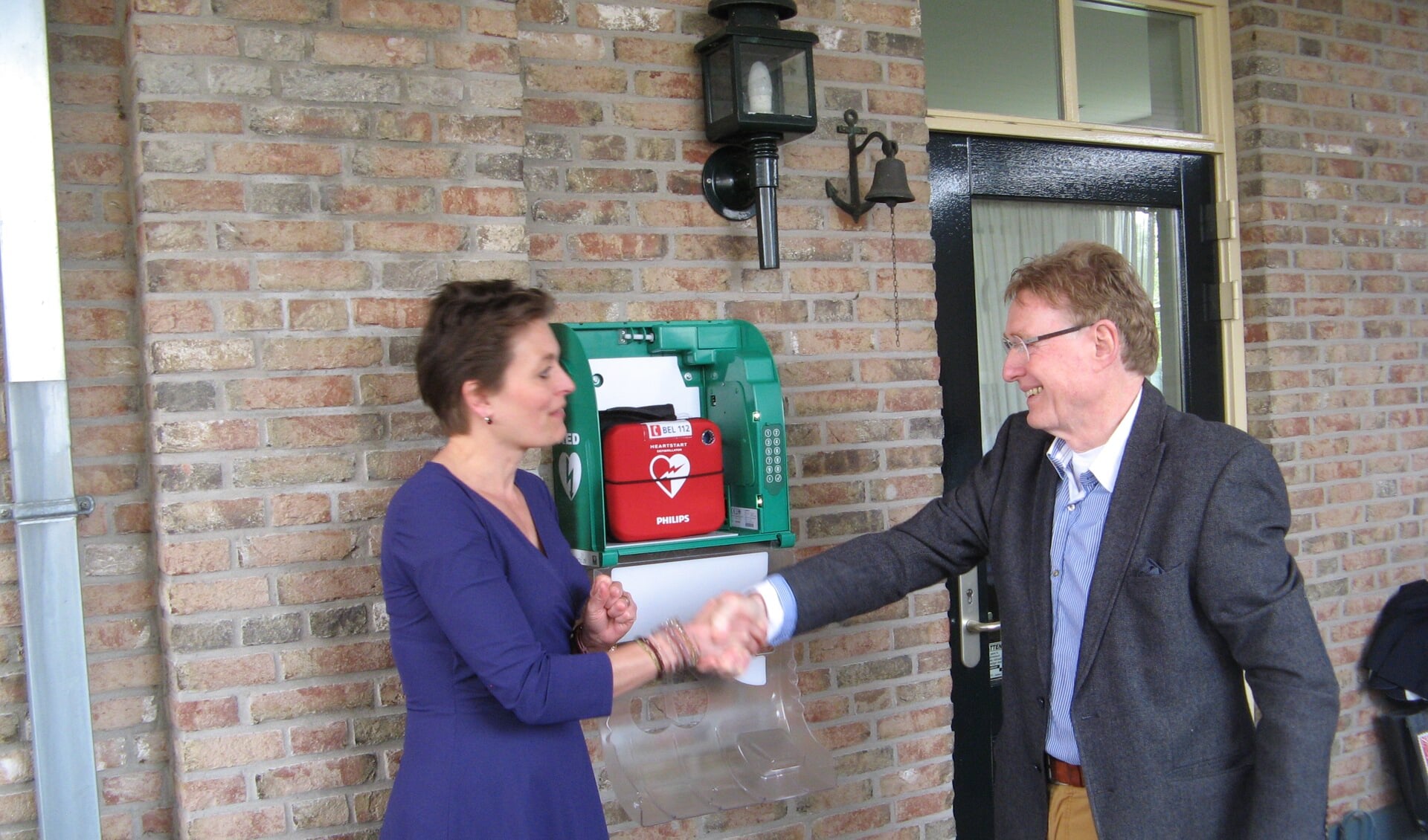 Wethouder Ilse Saris feliciteert Johan Esendam met de plaatsing van de eerste particuliere AED, geplaatst op de  Eelinkes. Foto: archief Achterhoek Nieuws - Bart Kraan