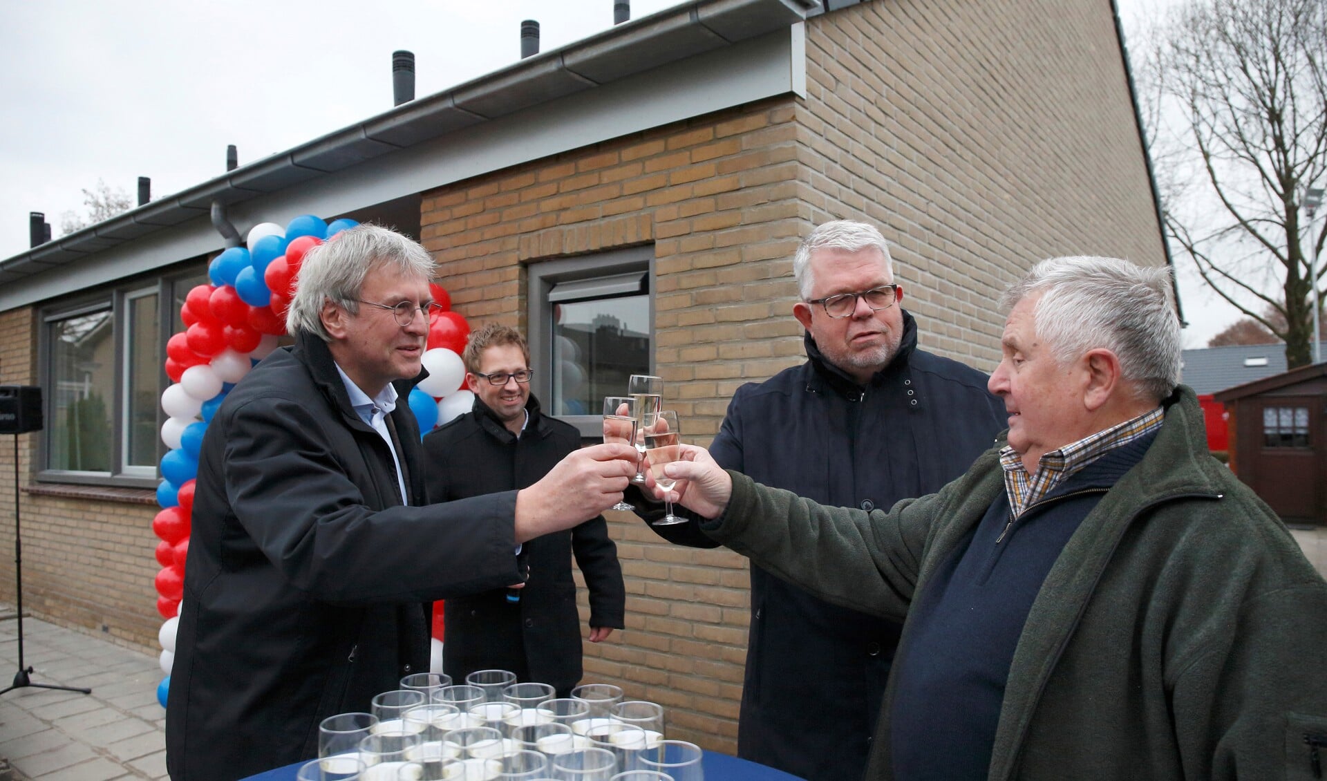 Wethouder Van Uem, Jan Stoel van ProWonen en dhr. Van Ingen proosten op de terugkeer van de bewoners. Projectleider Bart Ruiterkam bekijkt het tafereel. Foto: PR ProWonen