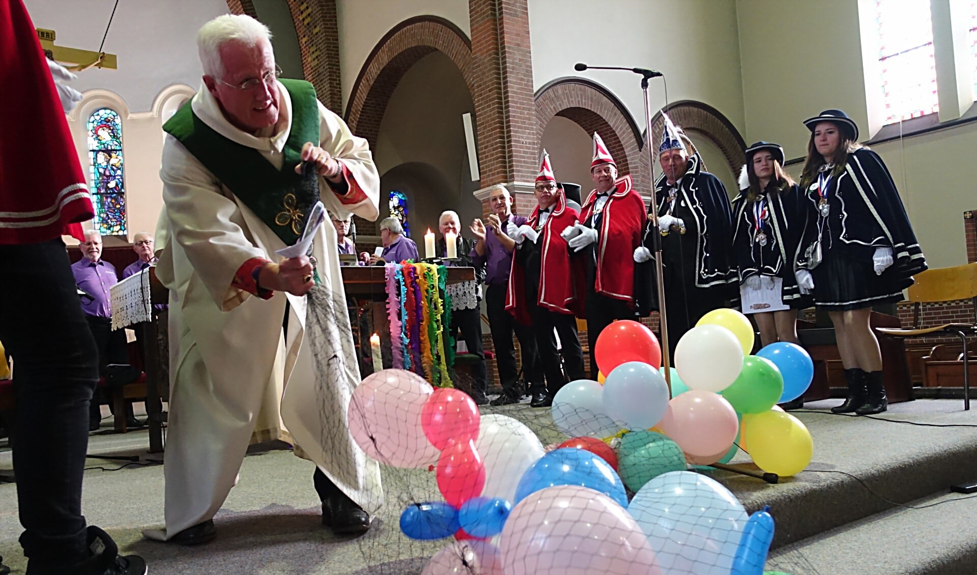Pastor Guus in de weer met ballonnen tijdens de ludieke mis. Foto: Guus Tinnevelt