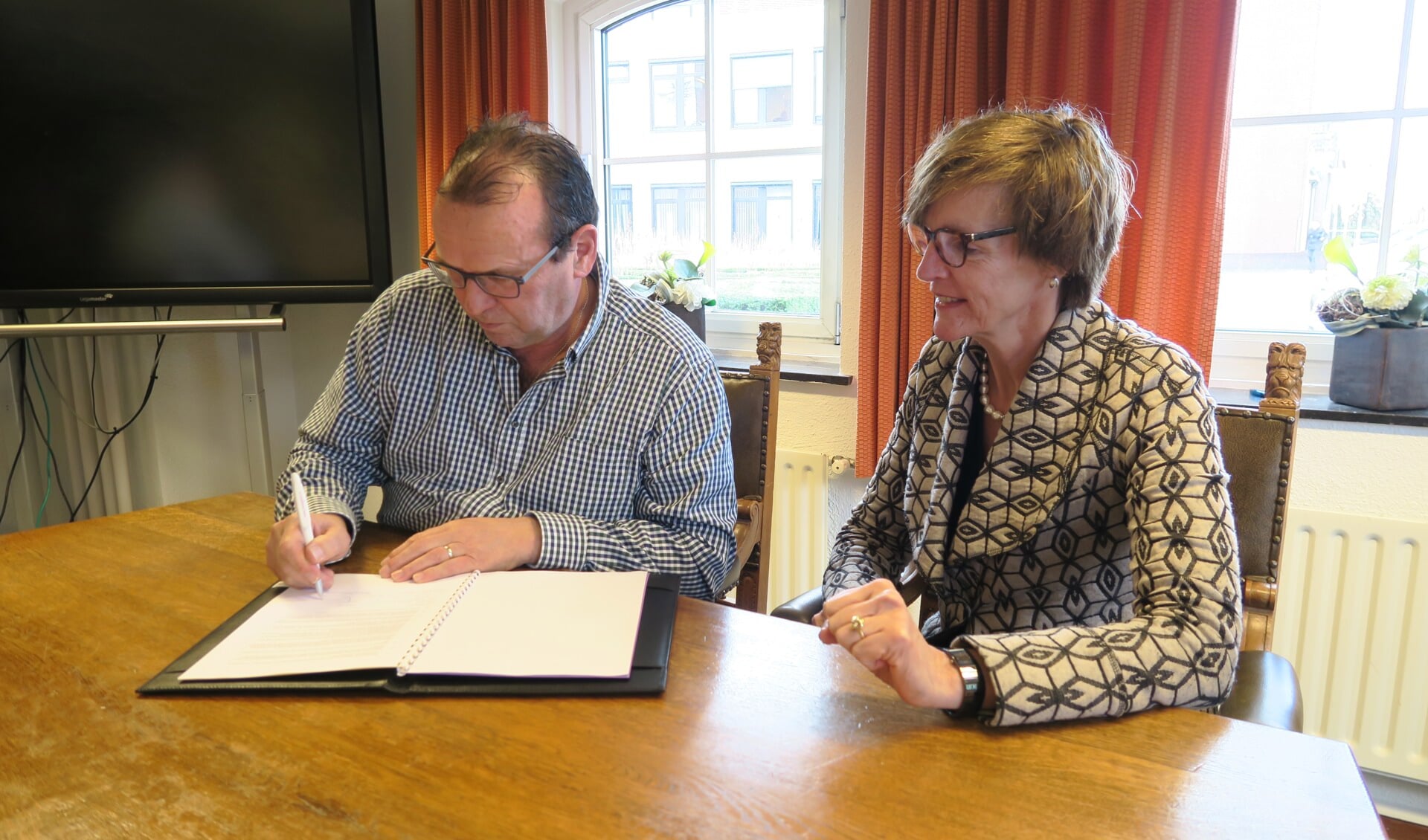 Ondertekening overeenkomst door Broddie Huinink onder het toeziend oog van burgemeester Annette Bronsvoort. Foto: Theo Huijskes