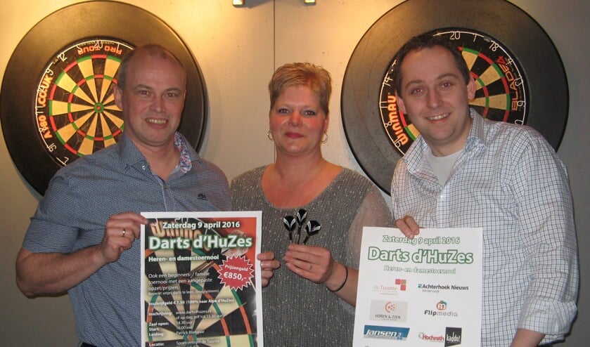 Arjan Kocken (links), De Tuunte-horecamedewerkster Patrice van Zuidam en Niels Blikman tonen posters die worden gebruikt om Darts d´Huzes te promoten. Foto: Bart Kraan