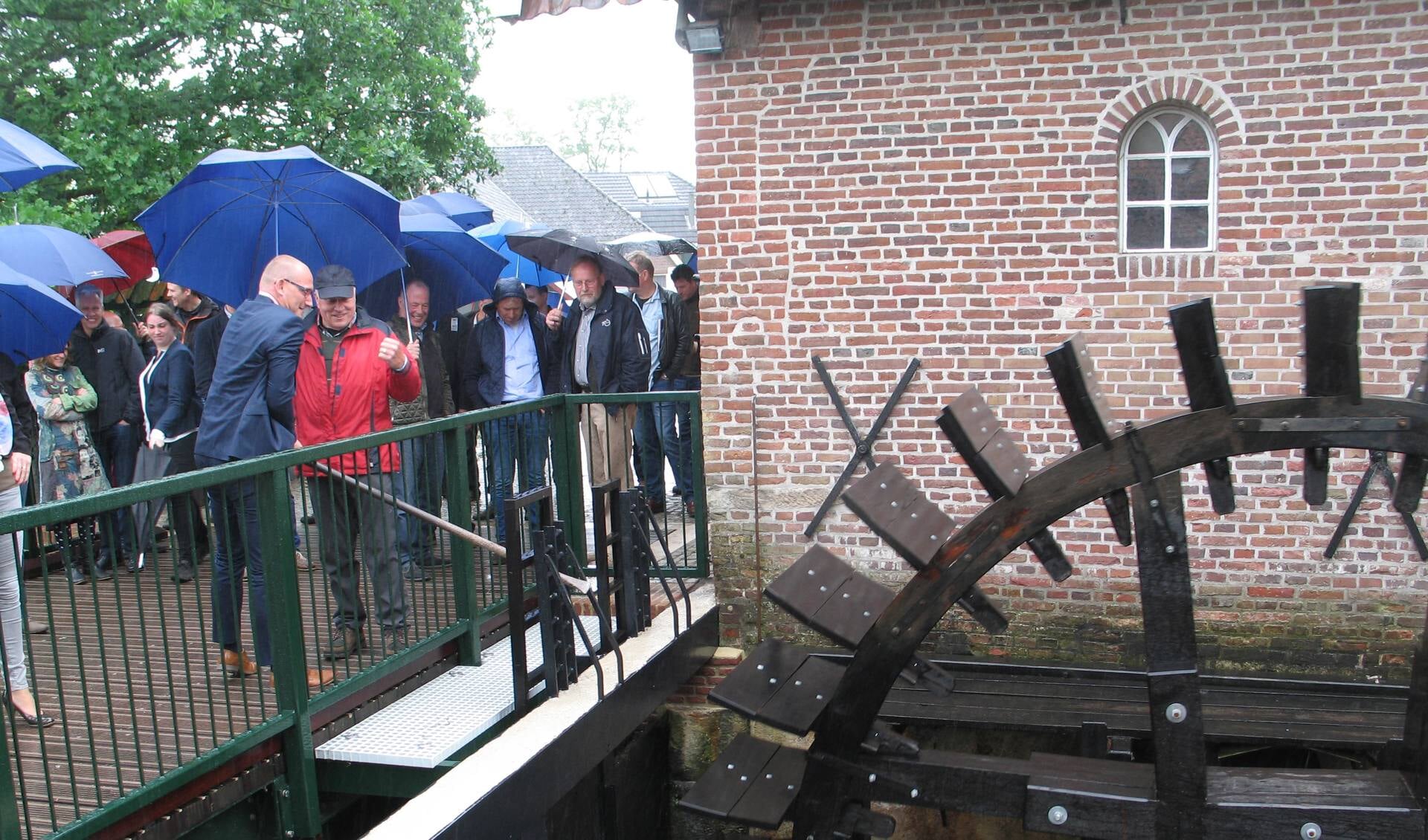 Wethouder te Gronde krijgt aanwijzingen van Willem Buunk bij het in beweging brengen van het nieuwe waterrad. Foto: Bernhard Harfsterkamp