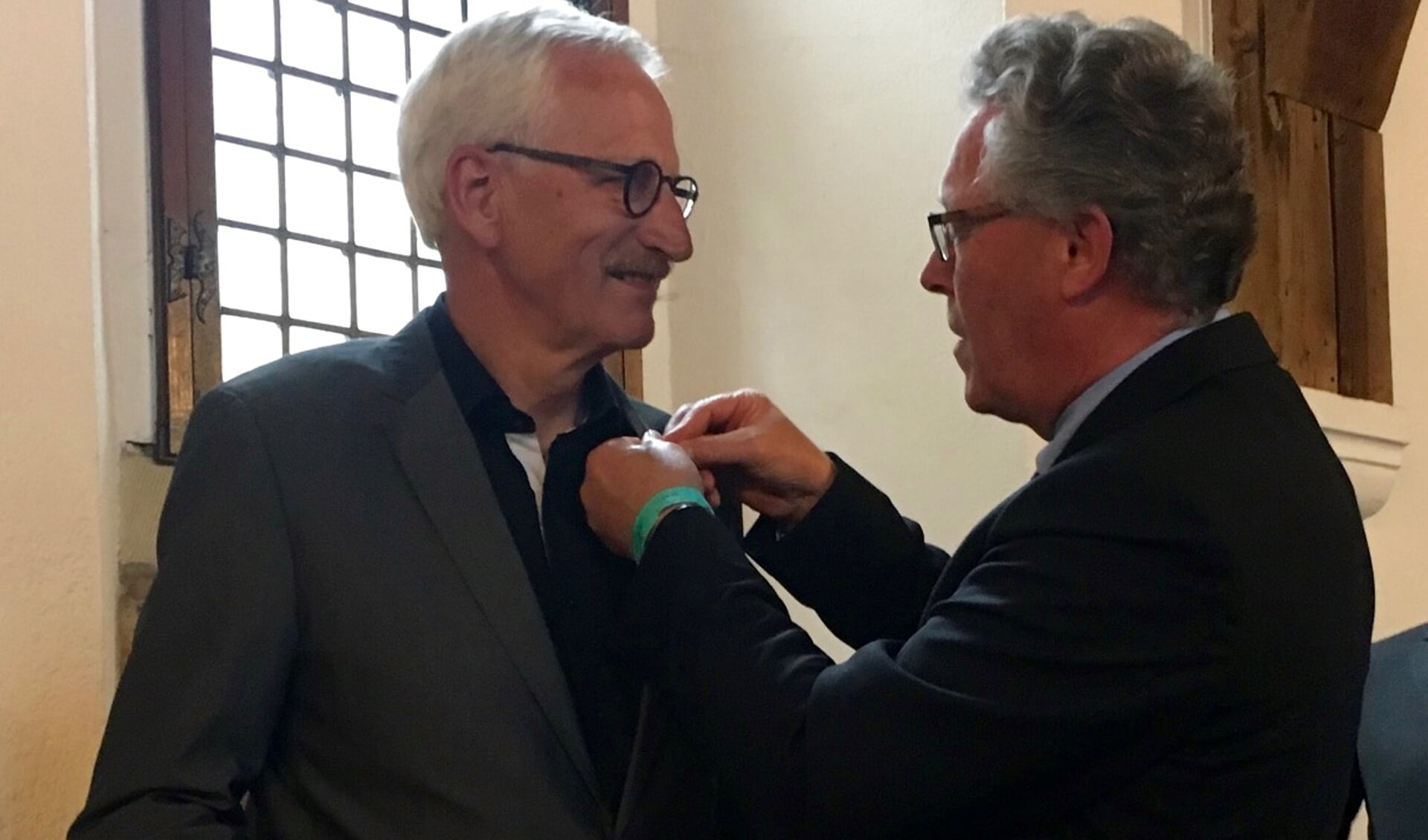 Jan Markink speldt Zilveren Haring op bij Arnold Gerritsen. Foto: PR
