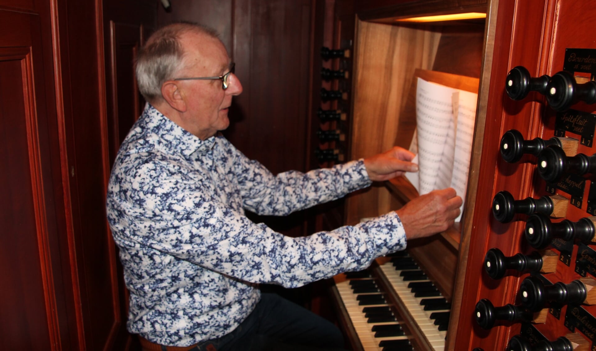 Gerrit Hietkamp zoekt, gezeten achter het orgel van Jacobskerk, een mooi psalm uit om te spelen. Foto: Lydia ter Welle