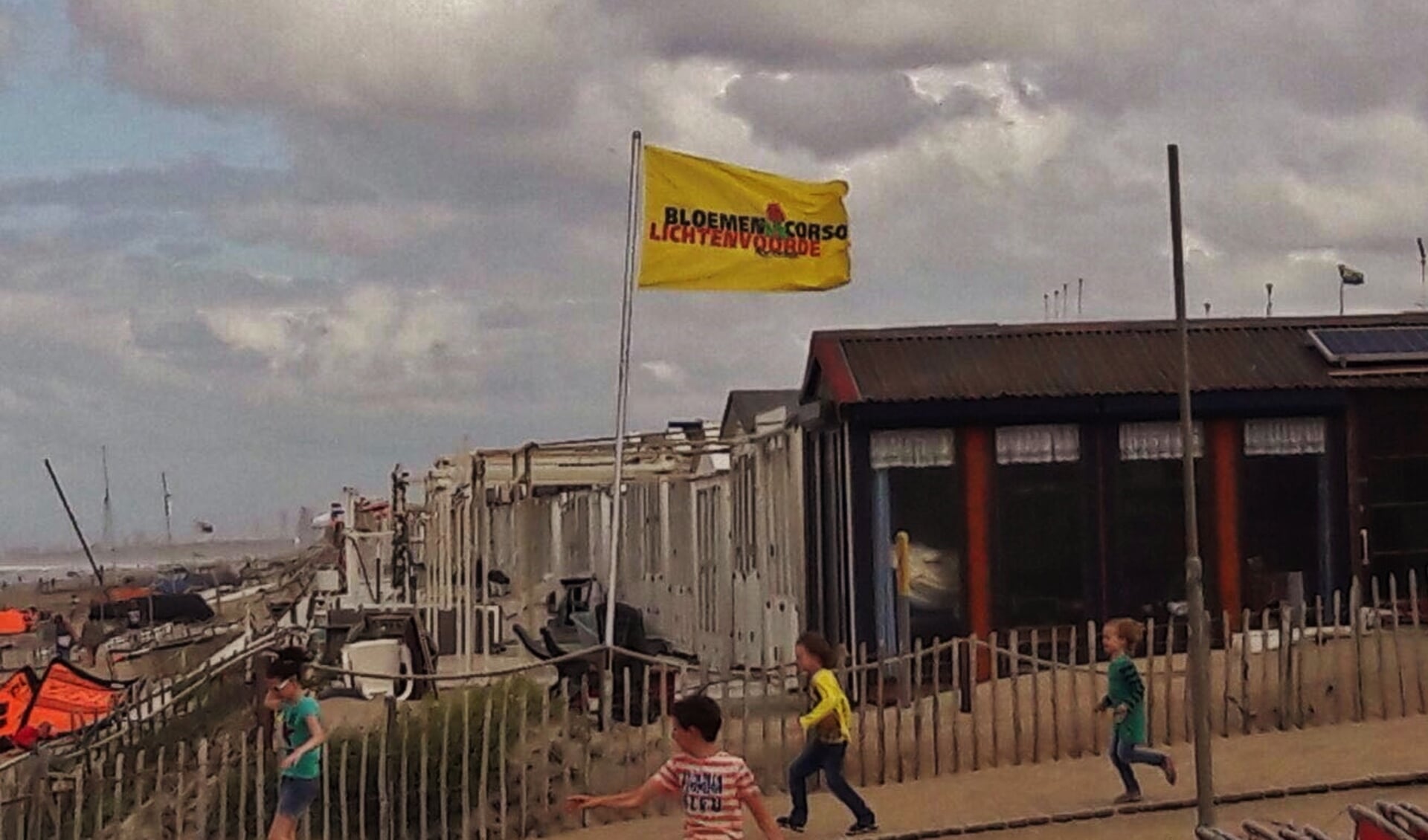 De Bloemencorsovlag wappert door de stevige wind fier in Zandvoort.