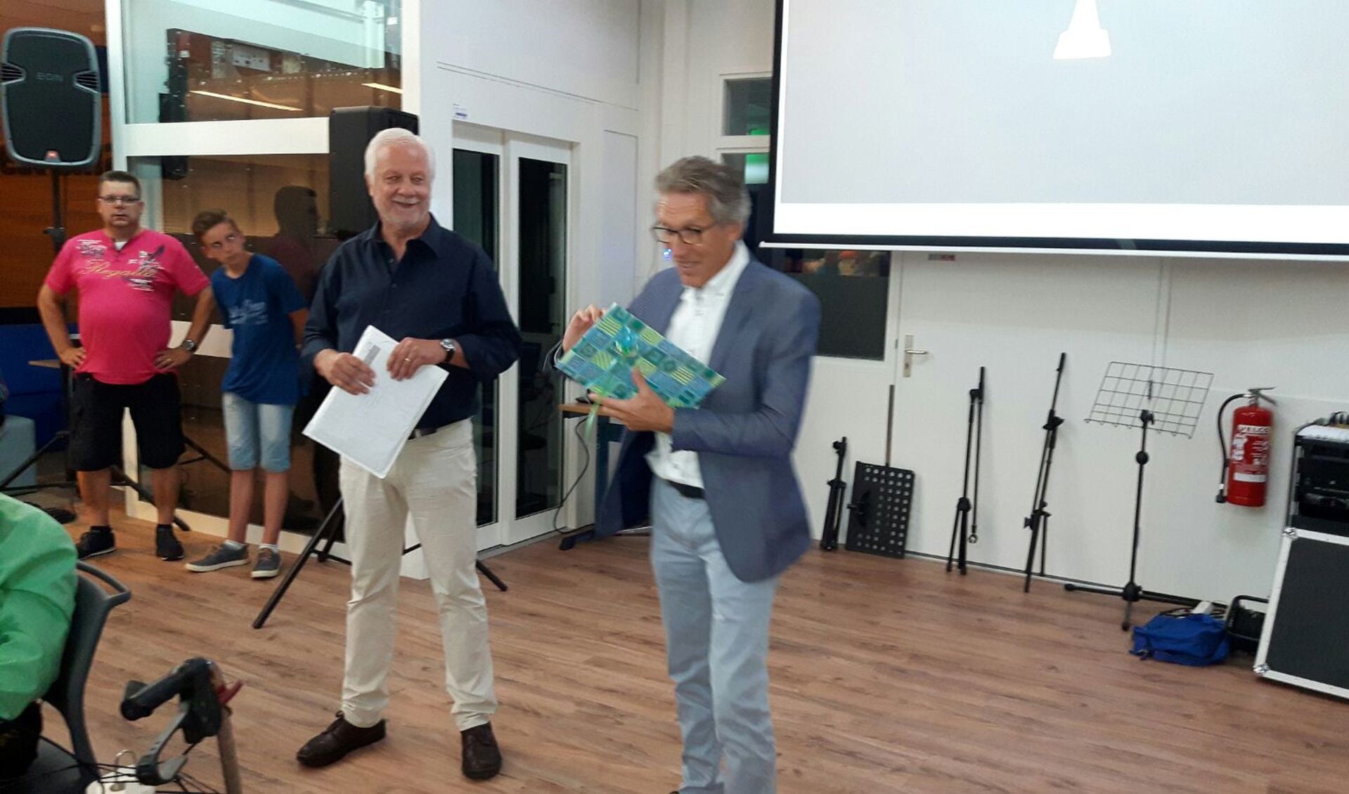 Links Geert Bongers en rechts de huidige directeur Johan van der Weerd die het eerste exemplaar van het boek ontvangt.. Foto: Kyra Broshuis