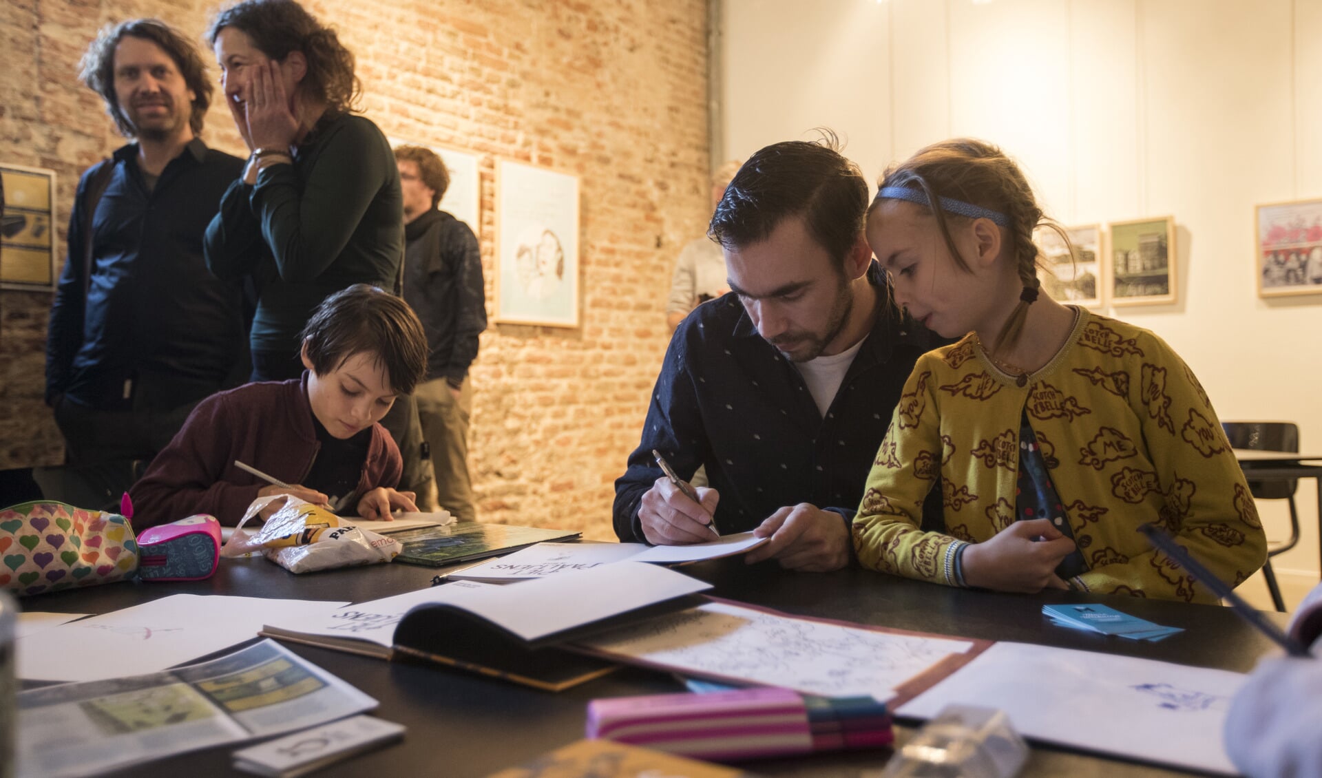 Marc Weikamp signeert een boek te midden van zijn zoon en dochter. Foto: Zutphens Persbureau/Patrick van Gemert