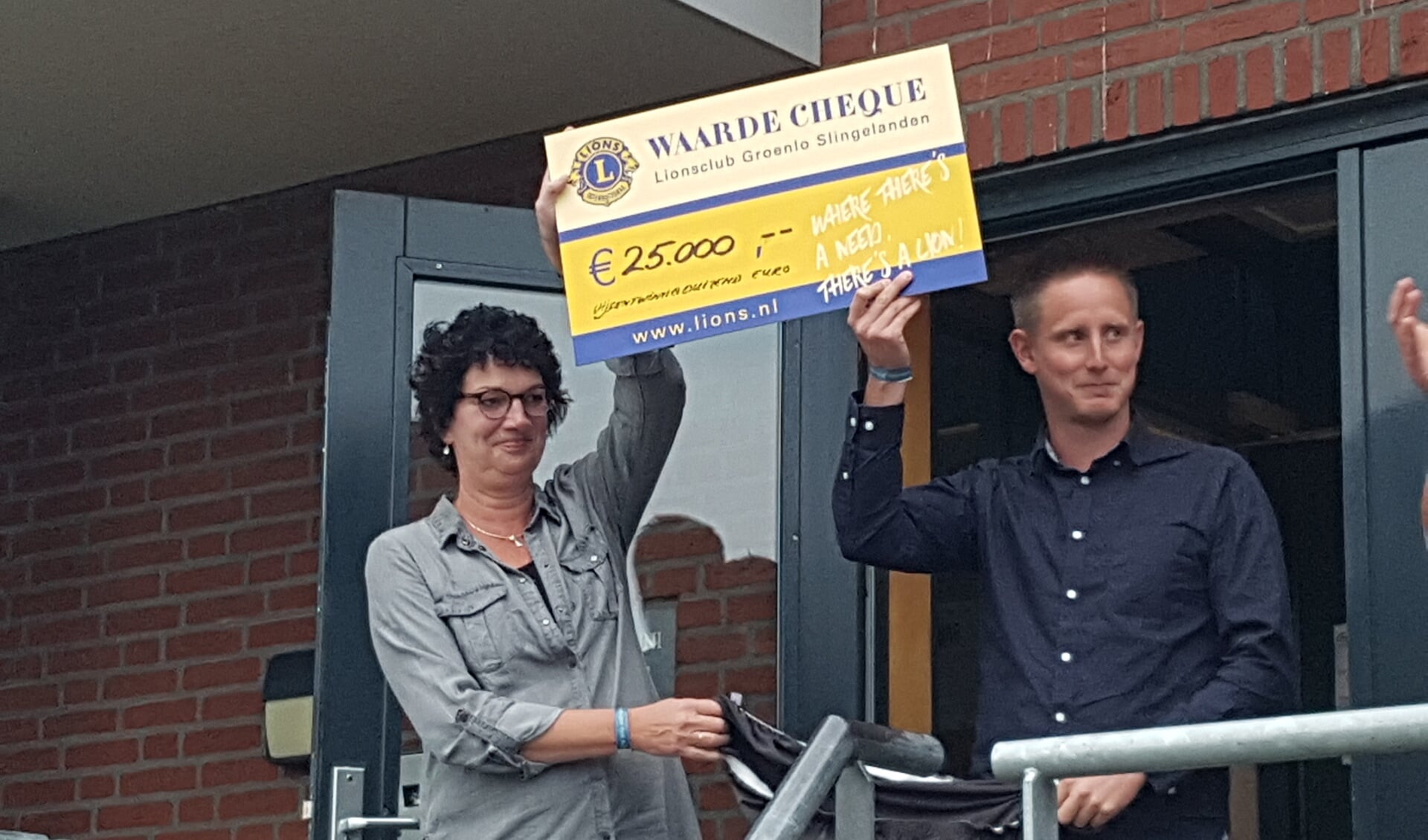 Marion Toebes en Lars Krabbenborg van de Stichting Huntington Oost Achterhoek met de cheque van de Lions. foto: Kyra Broshuis