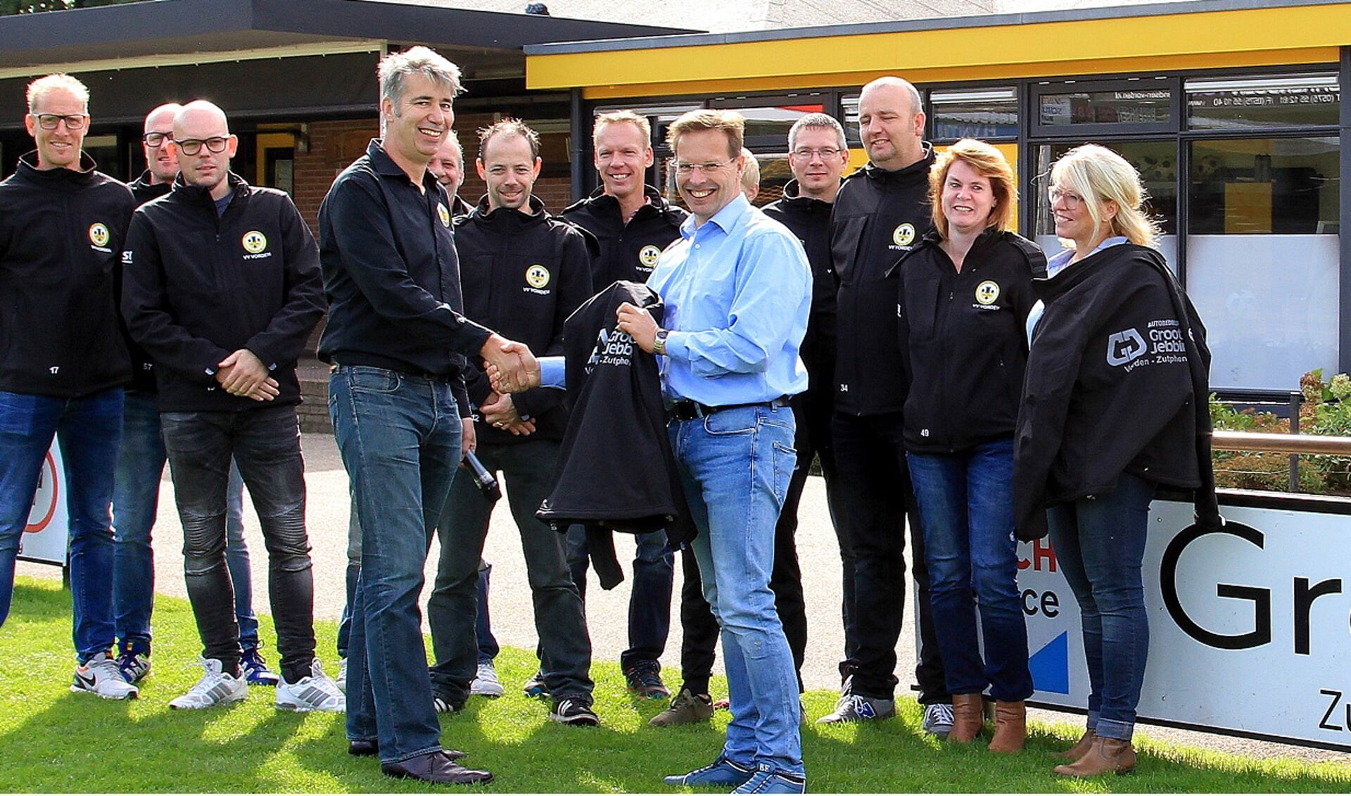 Hans Boers, sponsorcommissie v.v. Vorden, krijgt in het bijzijn van een tiental jeugdleiders symbolisch een jack overhandigd van Jan Groot Jebbink. Foto: PR