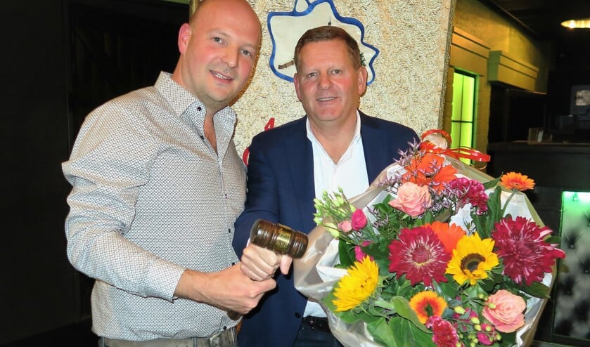 Rob Stokkers (rechts) overhandigt de voorzittershamer van CV De Knunnekes aan Maarten Kooiker. Foto: Theo Huijskes