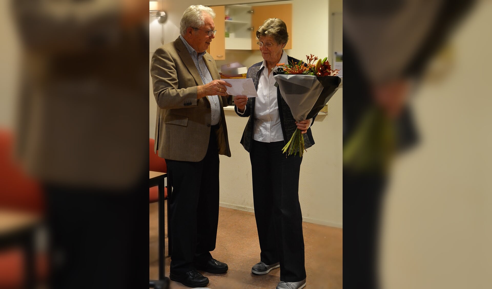 Jubilaris Annie te Bulte krijgt uit handen van de regio-afgevaardigde Bosman de oorkonde overhandigd. Foto: PR