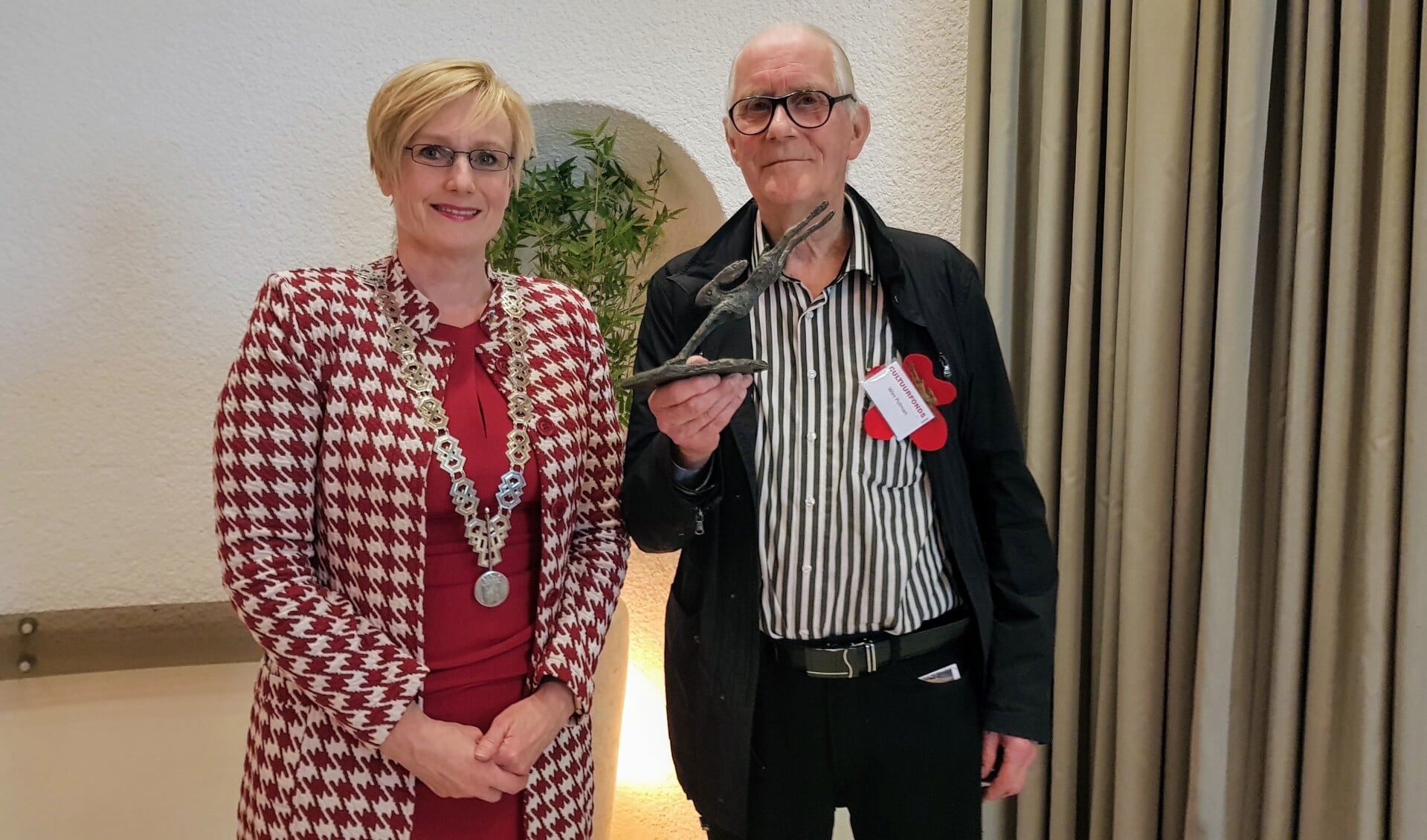 Wim Polman met de bronzen haas die hij ontving uit handen van burgemeester Marianne Besselink. Foto: Luuk Stam