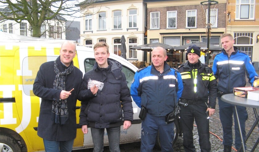 Burgemeester Bengevoord overhandigt een vuurwerkbril en aansteeklont, terwijl medewerkers Wim Meuleman en Jurgen Wubs en politieman Albert de Graaf toekijken. Foto: Bart Kraan