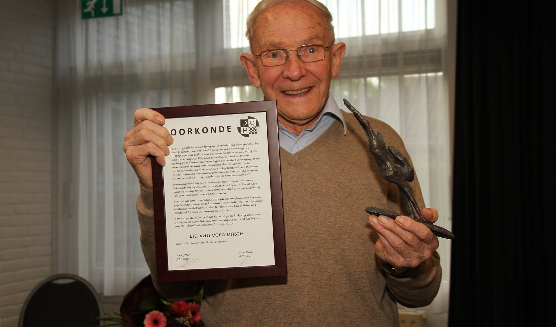 Damnestor Jan Heijink ontving zijn oorkonde van de dambond en een bronzen haas van de gemeente Bronckhorst voor zijn 80-jarig jubileum. Foto: Liesbeth Spaansen