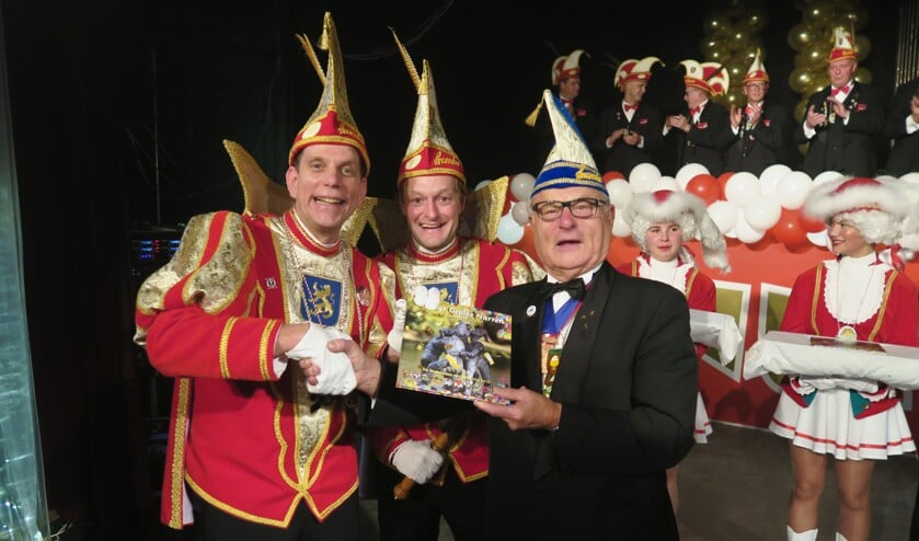Het huidige Prinsenpaar overhandigt de tweede editie van het jubileumboek aan carnavalist van het eerste uur: Cees van der Zant. Foto: Theo Huijskes