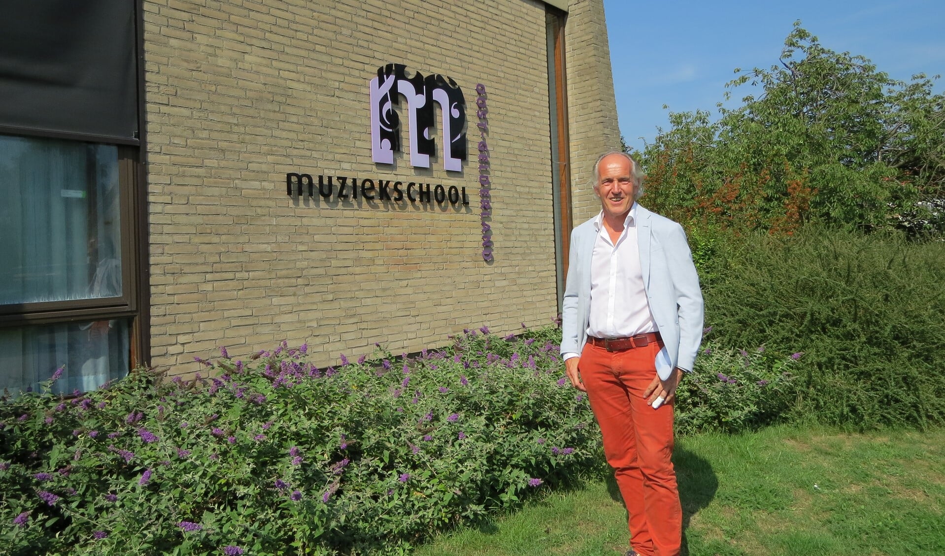Directeur Henk Lubberdink bij het monumentale muziekschoolgebouw.