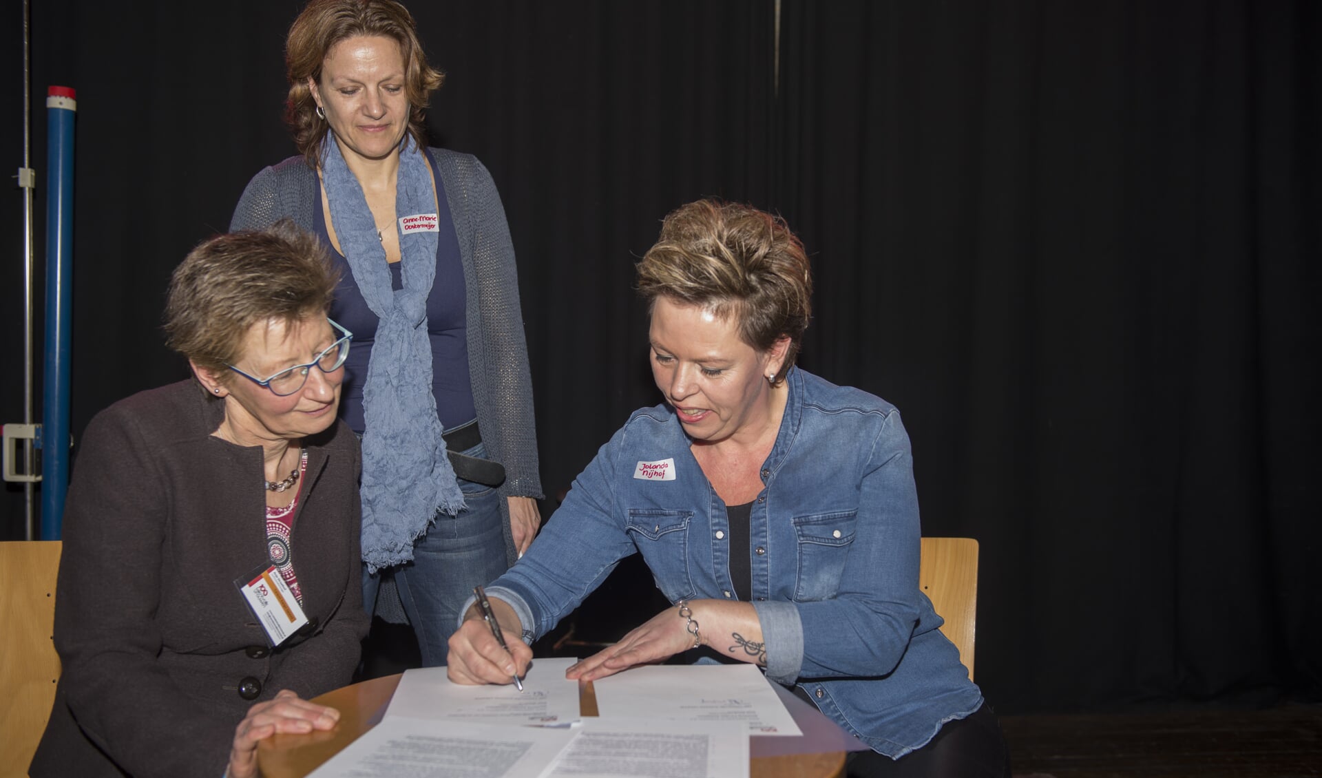 Jolanda Nijhof (r) ondertekent de licentie voor 100 talentvolle vrouwen in Zutphen, in het bijzijn van de oprichters van 100tv, Anne-Marie Oostermeijer (staand) en Anja Straathof (zittend). Foto: PR