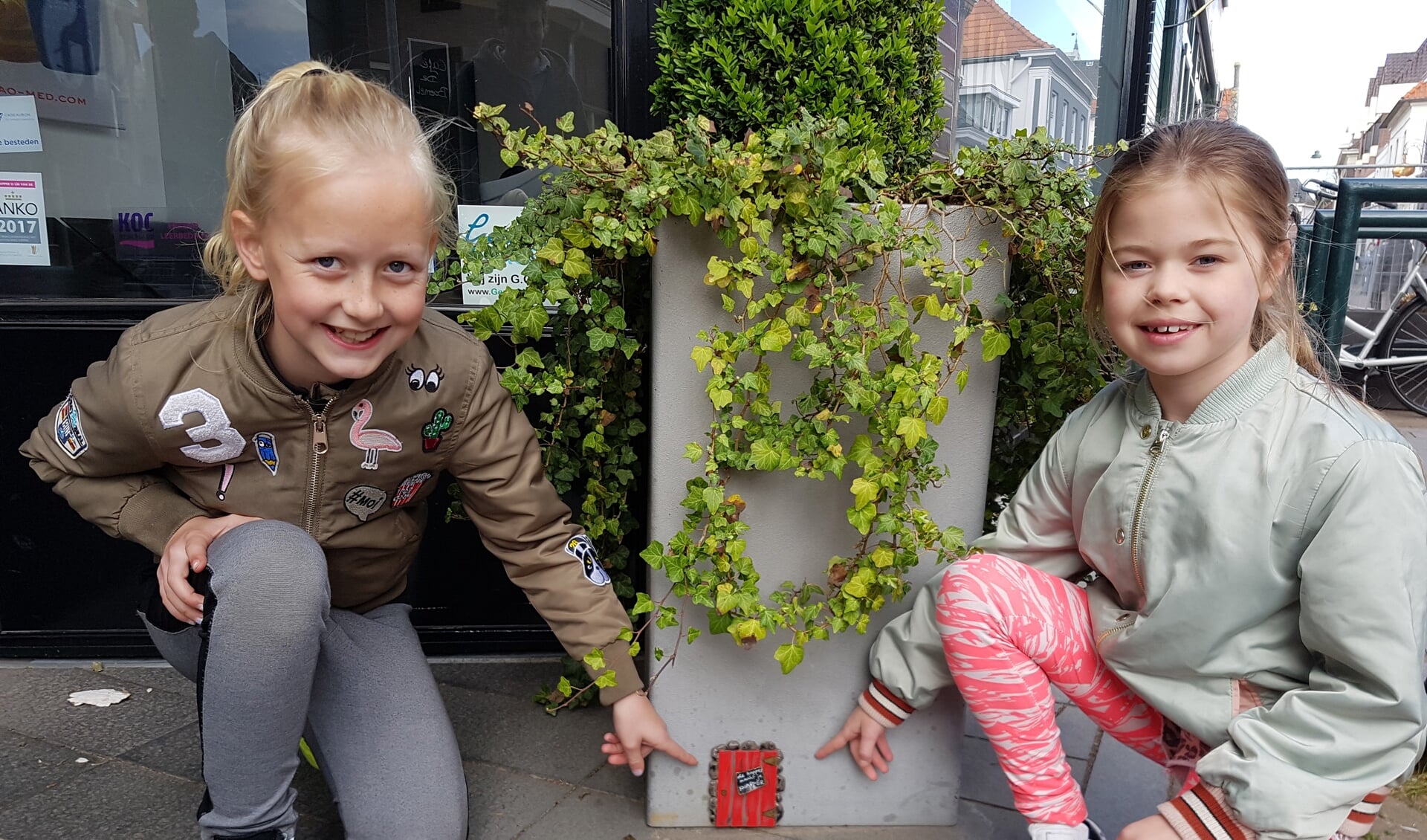 Guusje (l) en Salomé hebben een kabouterdeurtje ontdekt in Groenlo. foto: Kyra Broshuis