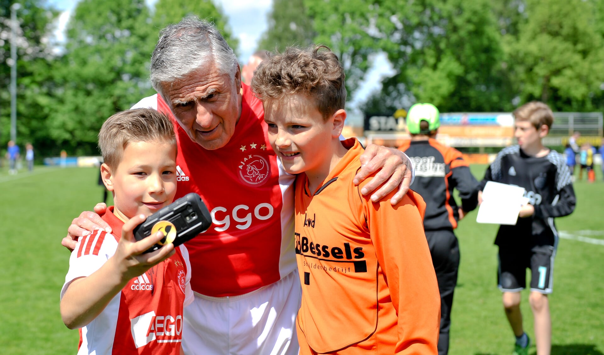 Jonge Keijenborgse voetballiefhebbers maken na afloop van de wedstrijd een selfie met ‘Mister Ajax’ Sjaak Swart (78). Foto: Achterhoekfoto.nl/John Mokkink
