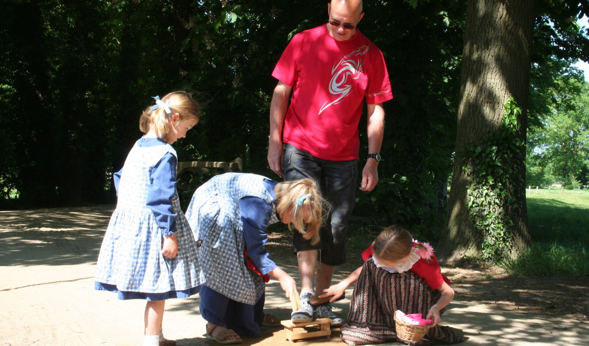 Kinderen poetsen de schoenen onder de Pinsterkroon. Foto: Ben Tragter