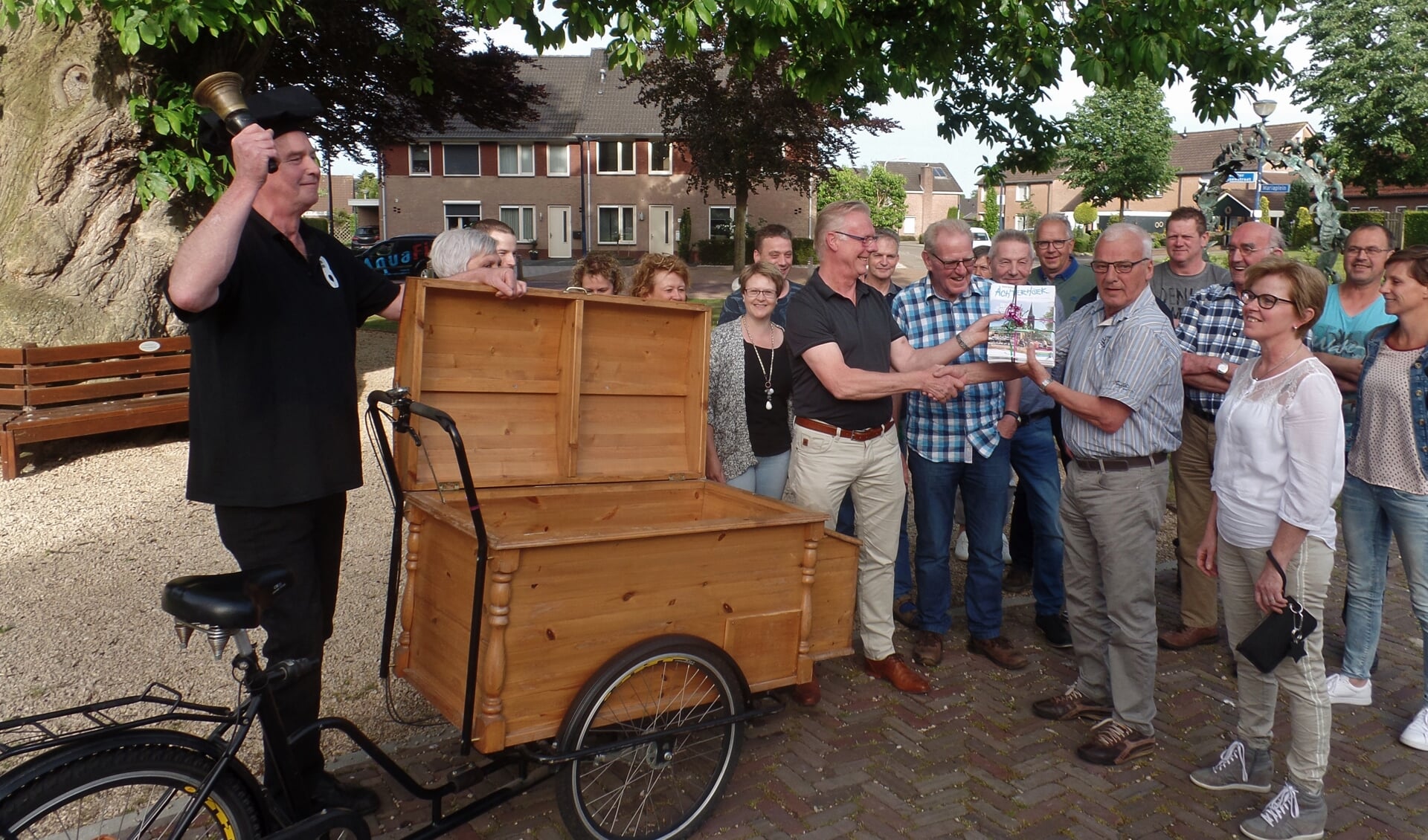 Bakker Stroet (links) deelt de folders uit, met behulp van Leo Scharenborg (rechts naast de bakfiets).