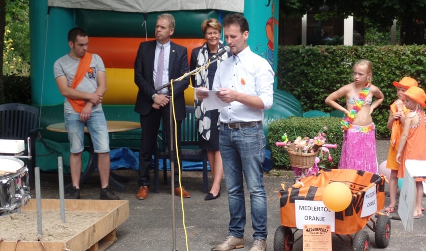 Voorzitter André Knoef van Stichting Oranjefeest Medlertol verwelkomde alle aanwezigen. Op de achtergrond wethouder Arno Spekschoor van de gemeente Bronckhorst en oud-koning Rick Knoef. Rechts enkele kinderen die deelnamen aan de optocht. Foto: Jan Hendriksen.
