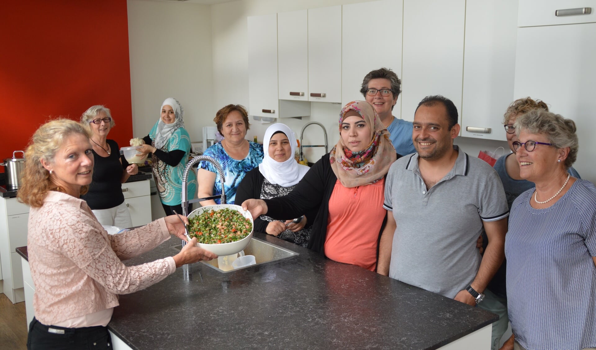 Deelnemers aan de avond laten in de keuken van Den Angang de Syrische tabouli zien. Foto: Helma te Grotenhuis 
