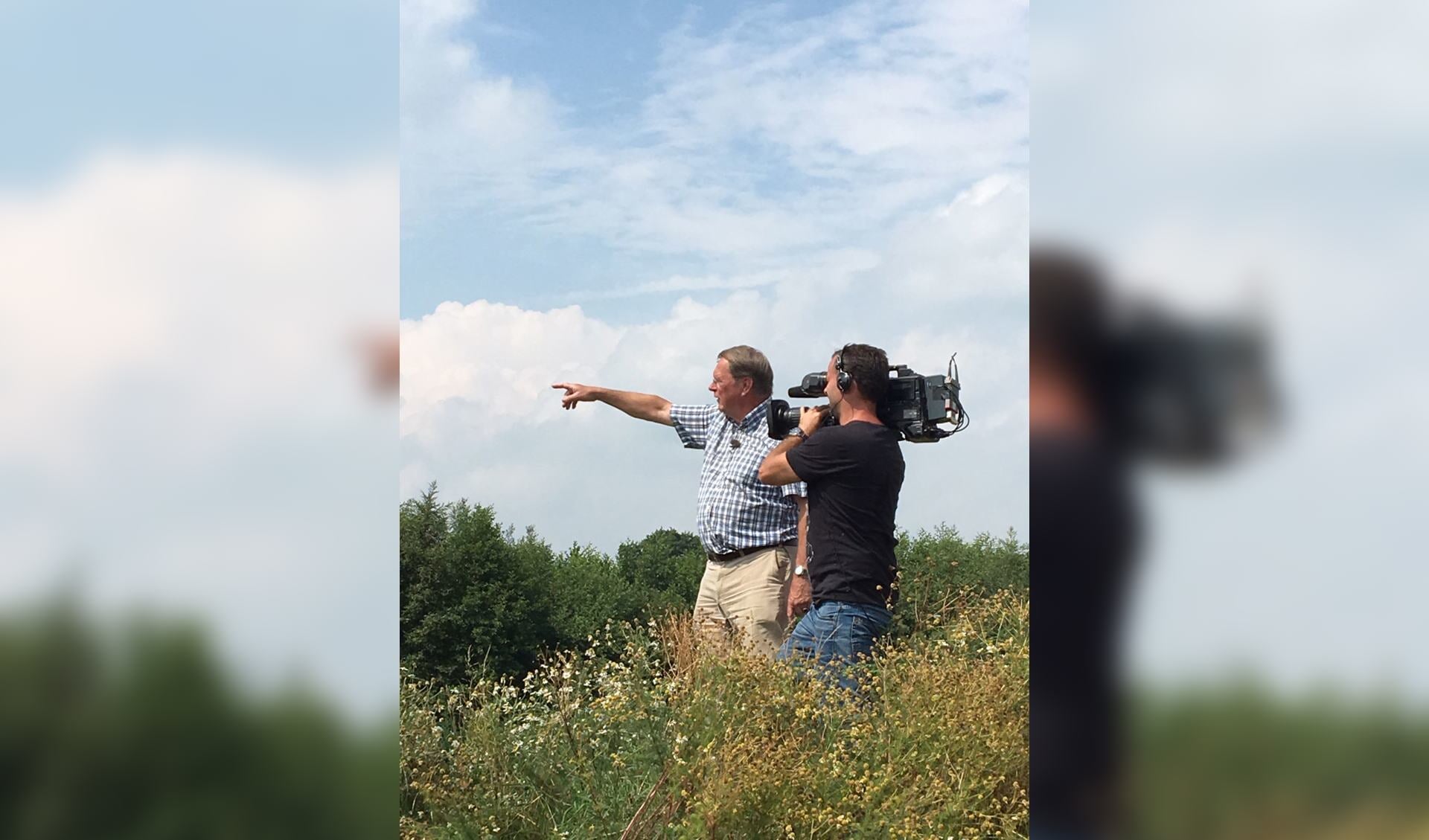 Jaap Cannegieter wijst de cameraman van Nieuwsuur waar de mestvergister in Groenlo gepland is. 