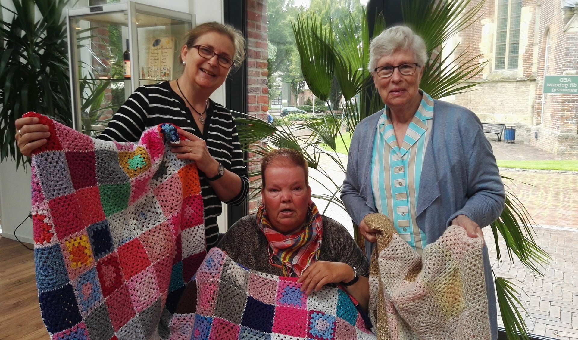 Johanna Locht (m) en Riet Tuinte (r) met hun Granny Squares dekens. Links Janny Hoenink, oprichtster Handwerkgroep 'De Bezige Bij'. Foto: Rob Weeber