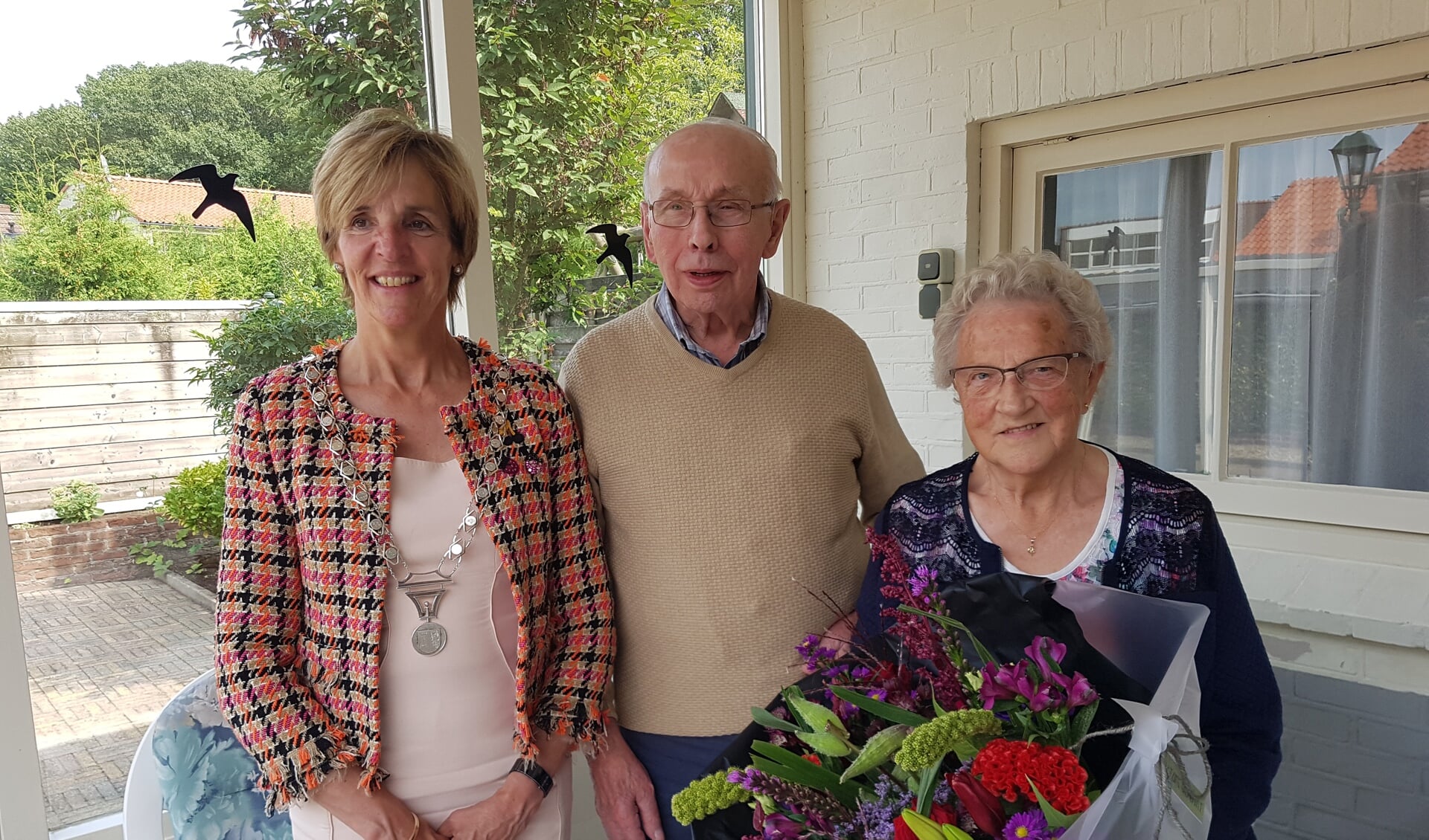 Burgemeester Bronsvoort brengt een prachtige bos bloemen mee voor het 65-jarig bruidspaar Gerard en Trees Meekes-Schuurmans. Foto: Kyra Broshuis