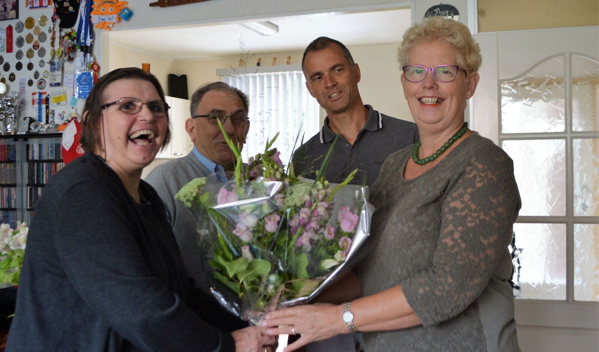 Marina van der Zee (links) krijgt de bloemen van wethouder Coby Pennings. Naast haar Rob van der Zee en Ben Dull. Foto: PR