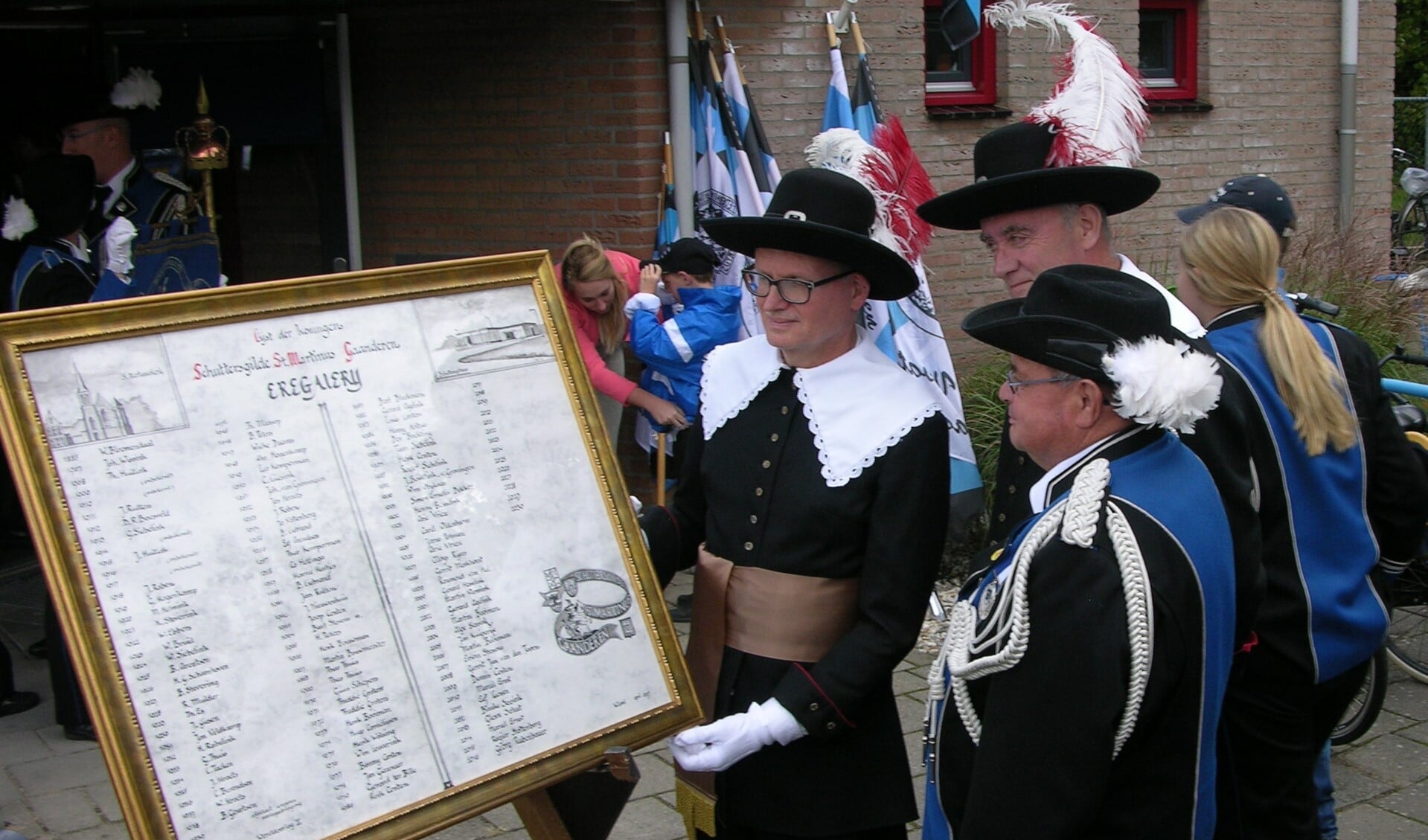 Wim Land en Simon Dekker overhandigen de plaquette aan voorzitter Gerard Huntink (vlnr). Foto: John van der Kamp