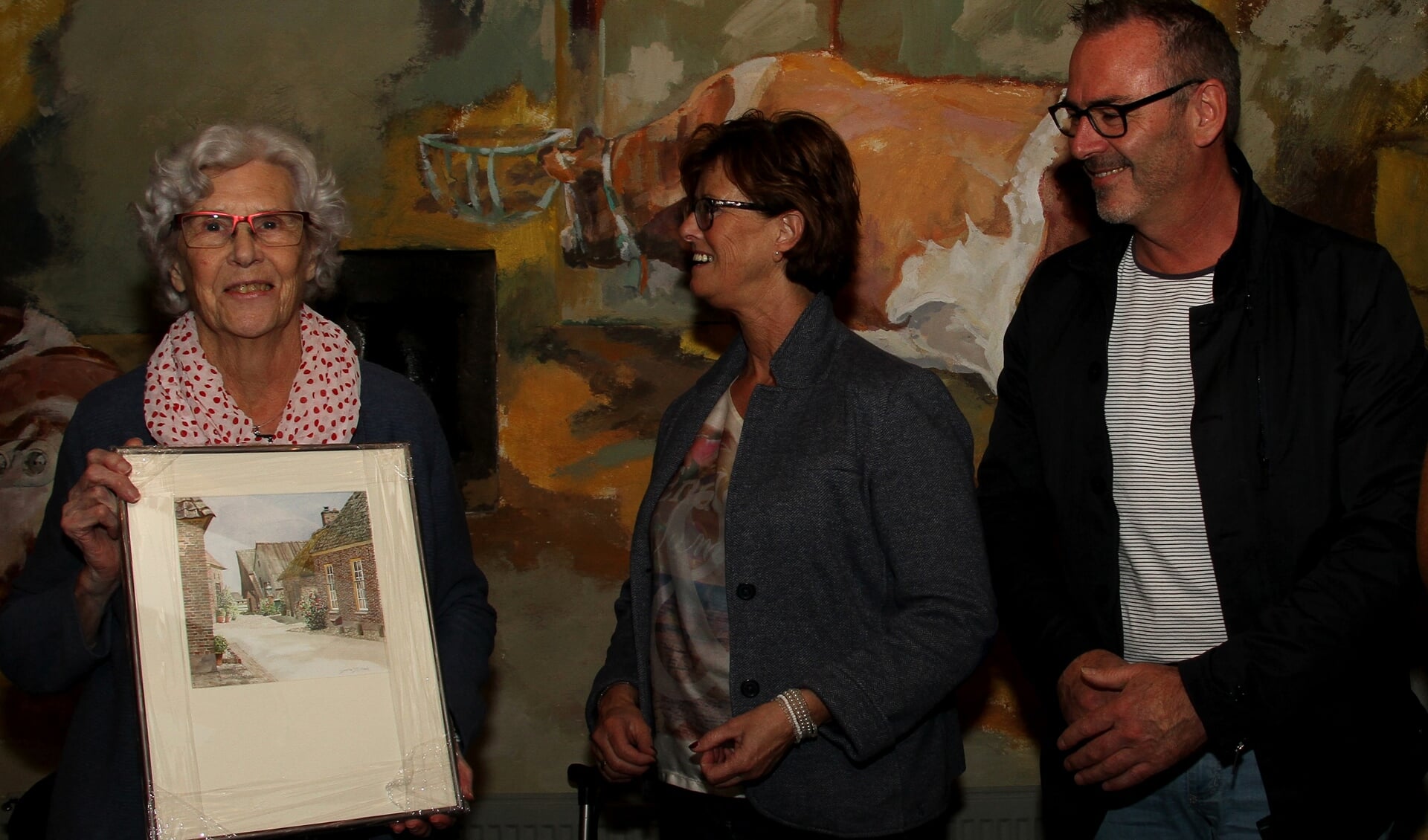 Alie de Jong (l.) krijgt van Marian Zuidema en Maarten ten Have namens het Gilde bloemen en schilderijen. Foto: Liesbeth Spaansen
