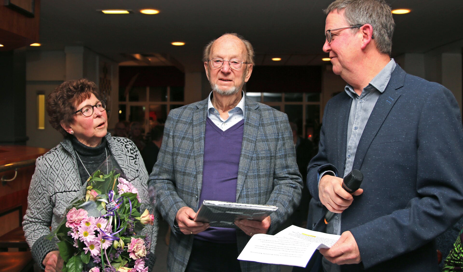 Gerard Schepers (m.) en zijn vrouw Annie werden tijdens de nieuwjaarsbijeenkomst in het zonnetje gezet door voorzitter Henk Sleumer. Foto: PR