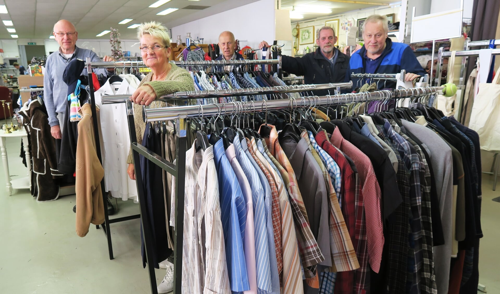 Enkele vrijwilligers met geheel links Jan ter Dolle in de Vincentius-winkel. Foto: Theo Huijskes