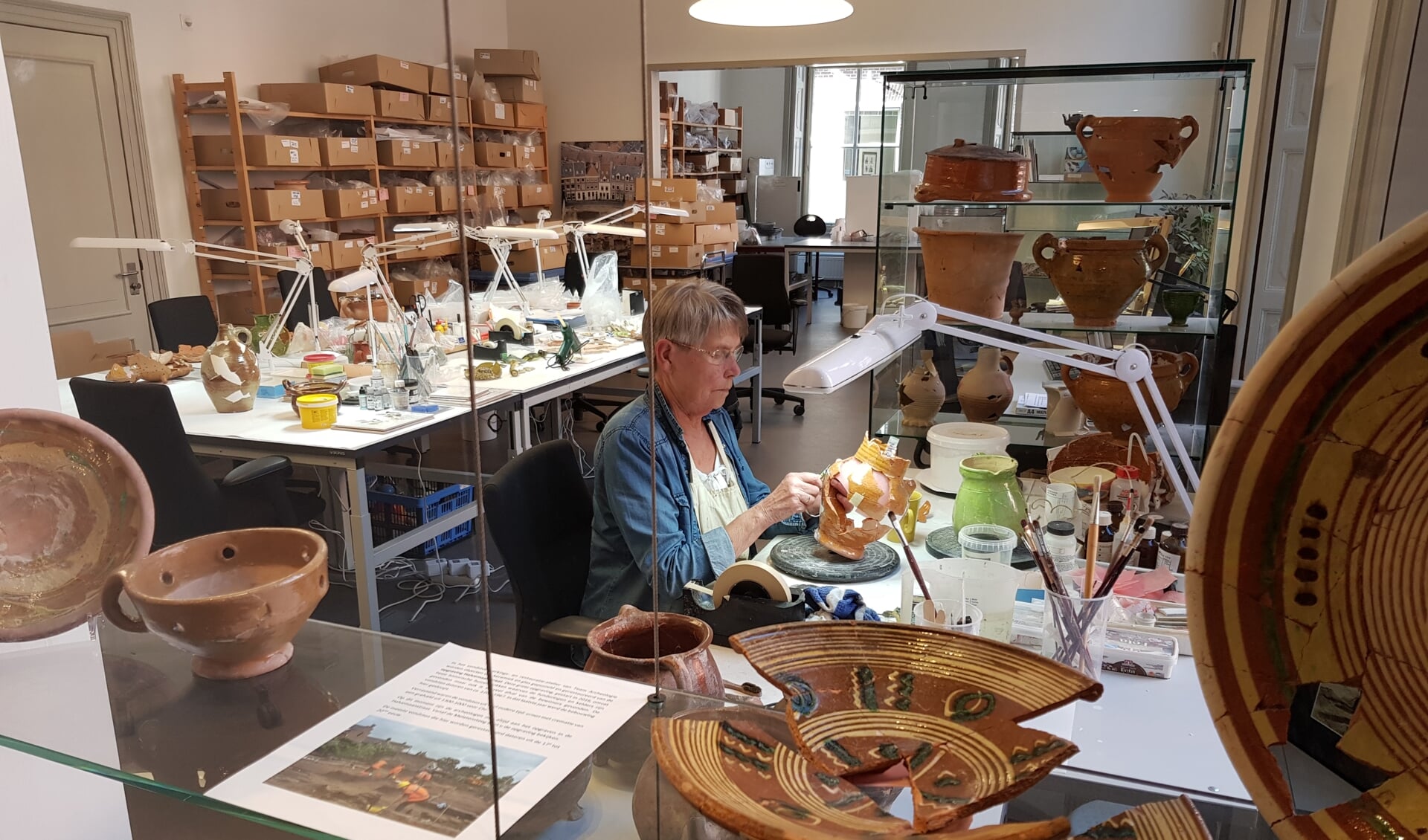 Vrijwilligers Archeologie geven uitleg over het restaureren van aardewerk objecten. Foto: PR