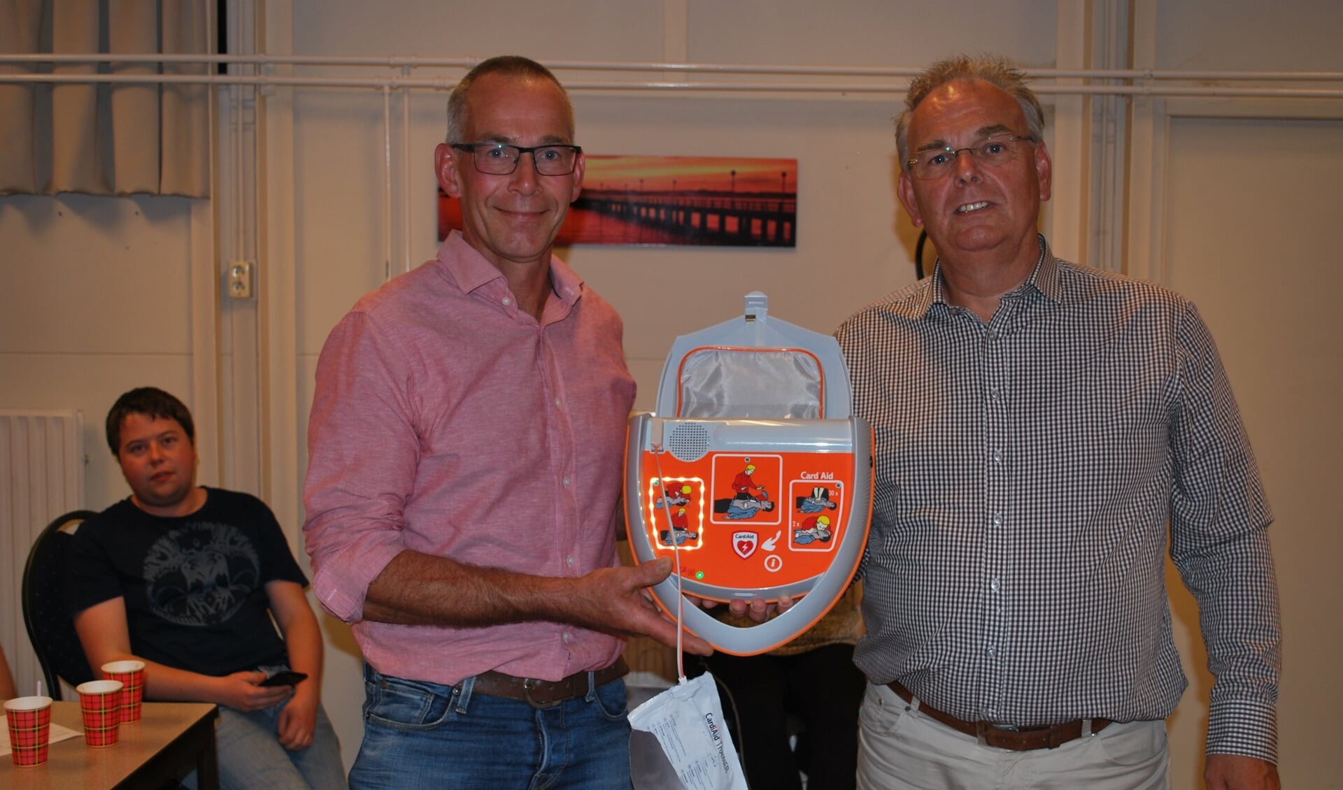Jan Willem Jolink, voorzitter van buurtvereniging Wassinkbrink, neemt de AED in ontvangst van de firma Cardi Aid. Foto: Margreet Nusselder