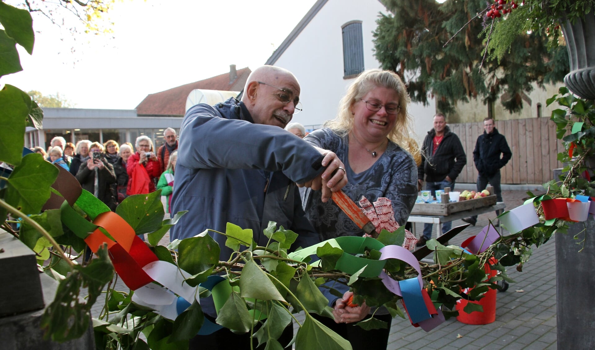 Meester Arnold Janssen helpt Josja van Mierlo met de officiële opening van haar bloemenlokaal. Foto: Liesbeth Spaansen
