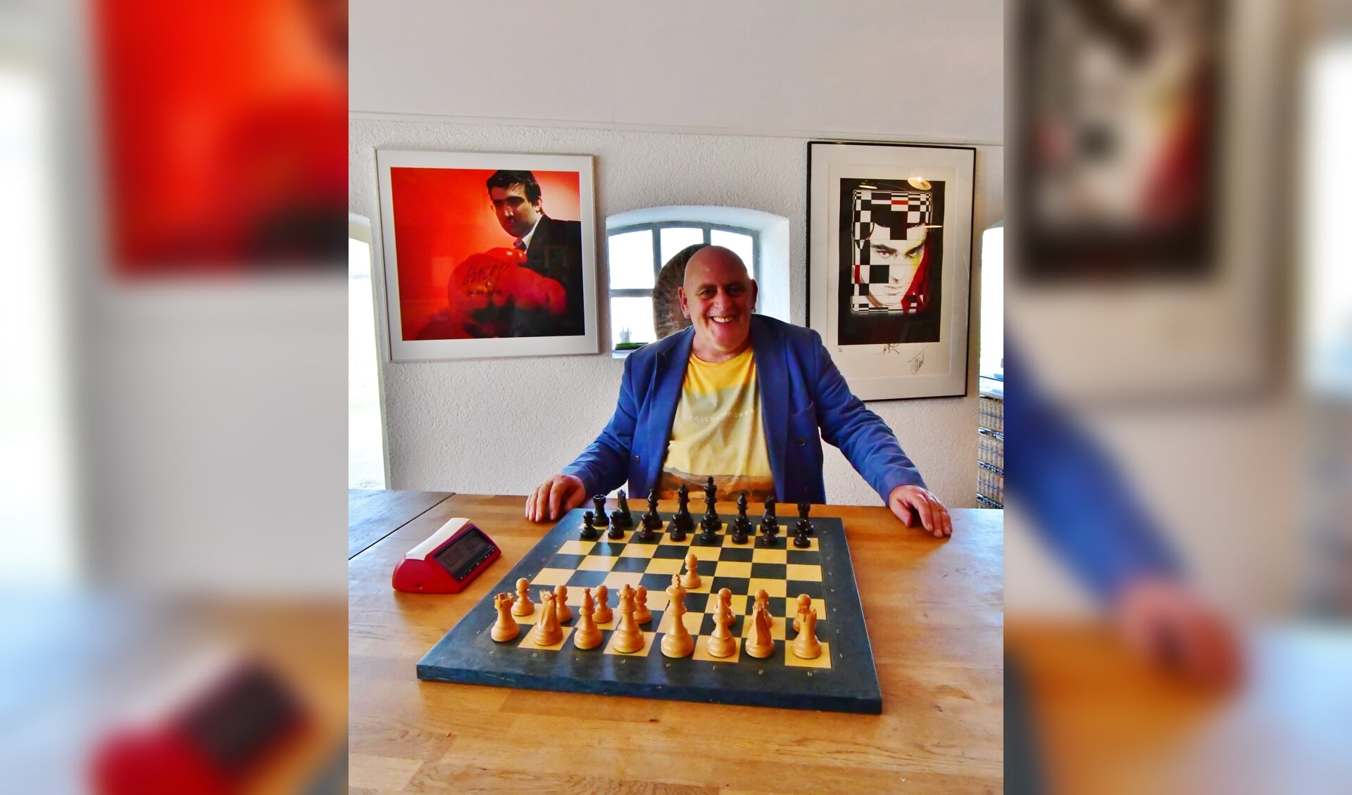 Albert Vasse achter het schaakbord met daarnaast de digitale schakkklok die het ontwikkelde. Foto: Kees Avé. 