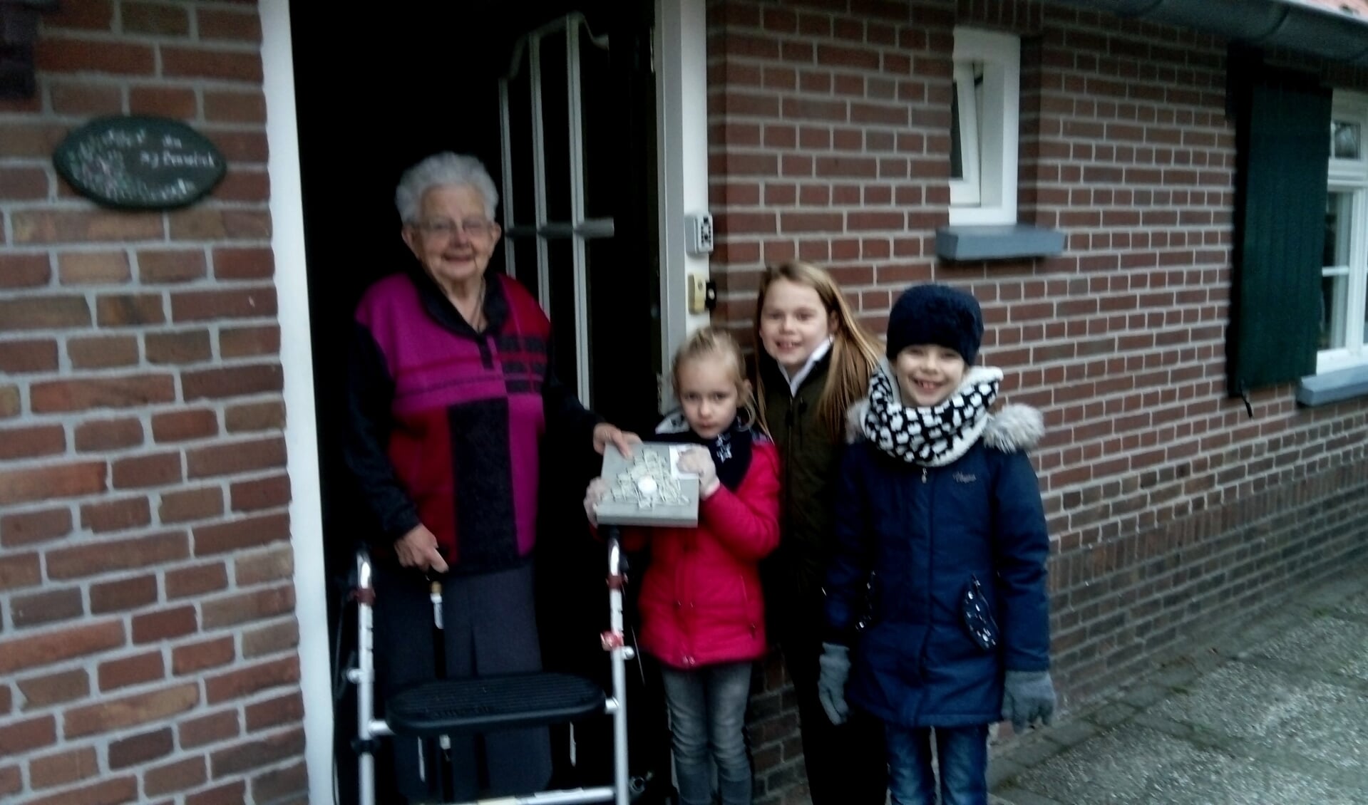 Mevrouw Lenselink neemt de kerstattentie in ontvangst van Roos, Mirte en Lieke. Foto: Alice Jolink