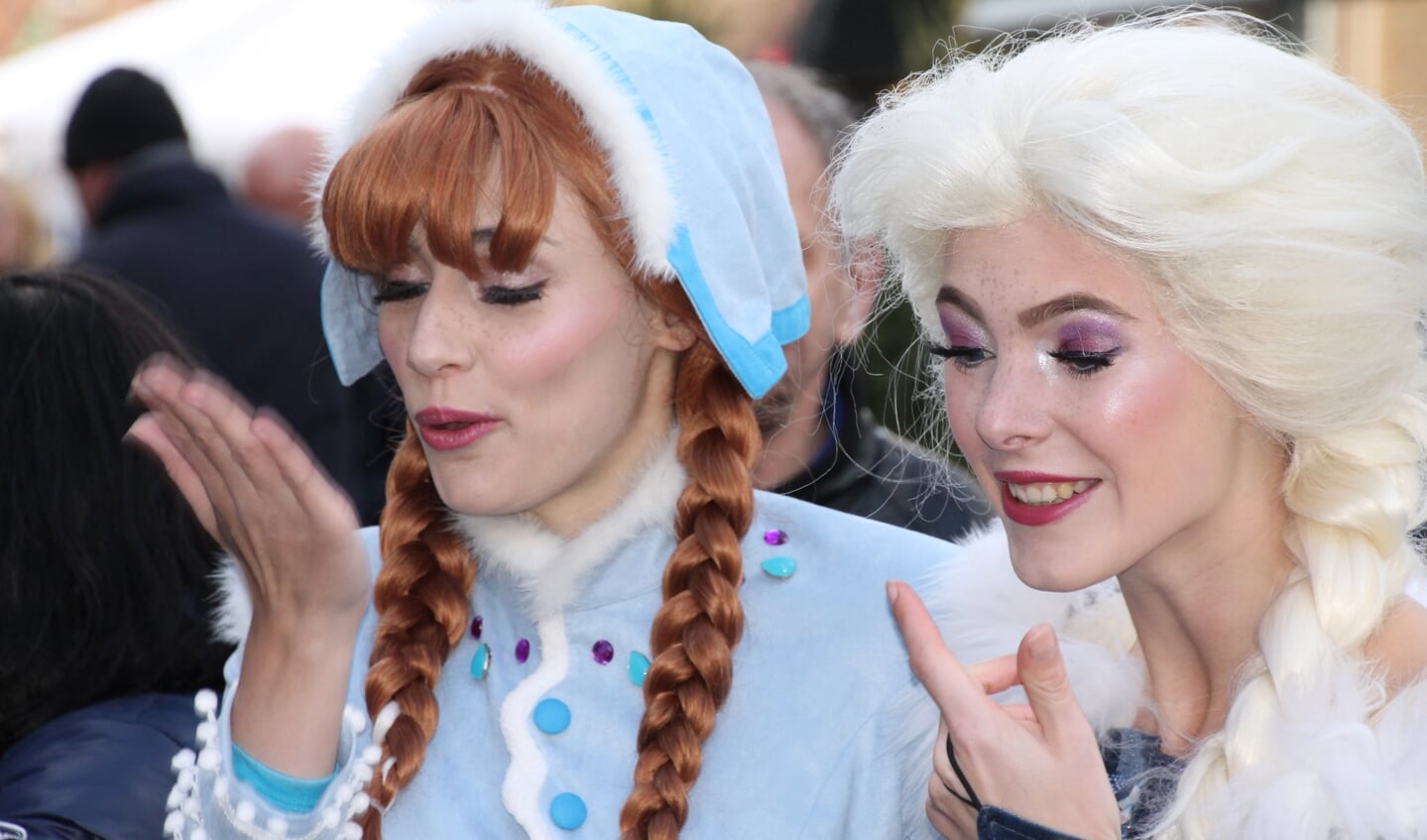 De ijsprinsessen uit Frozen, Anna en Elsa, delen handkusjes uit. Foto: Jos Betting