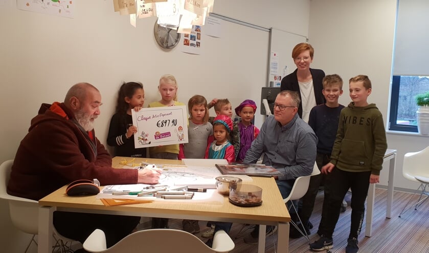 Leerlingen overhandigen een cheque voor een groener schoolplein. Foto: Imalda Dragt