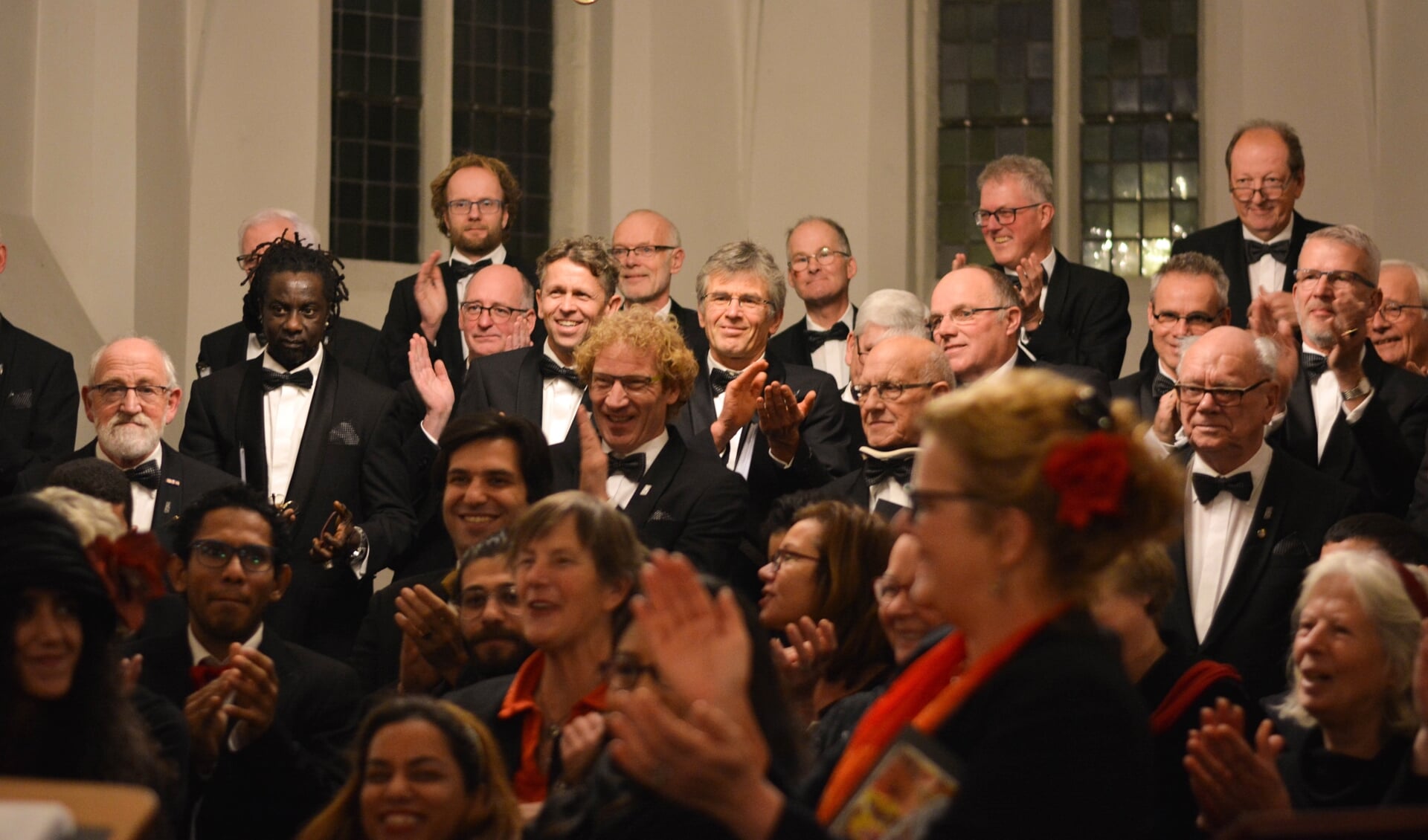 De twee koren applaudisseren voor elkaar aan het slot van hun optreden in de Martinuskerk. Foto: Caitlinrsphoto