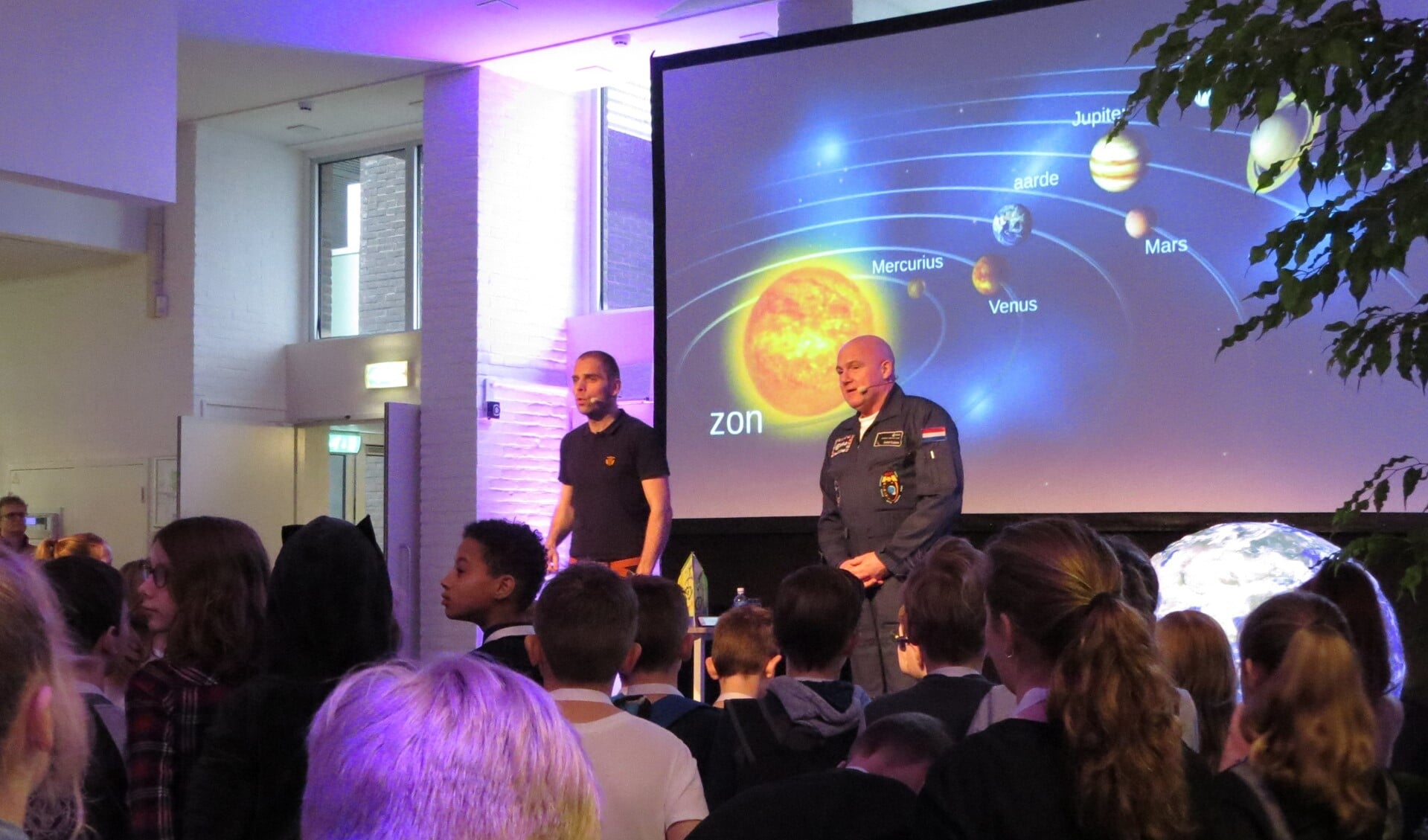 André Kuipers en Sander Koenen (links) gooiden zojuist een balletje de zaal in om uit te leggen hoe een raket het handigst in een baan om de aarde kan worden gebracht. Foto: Josée Gruwel