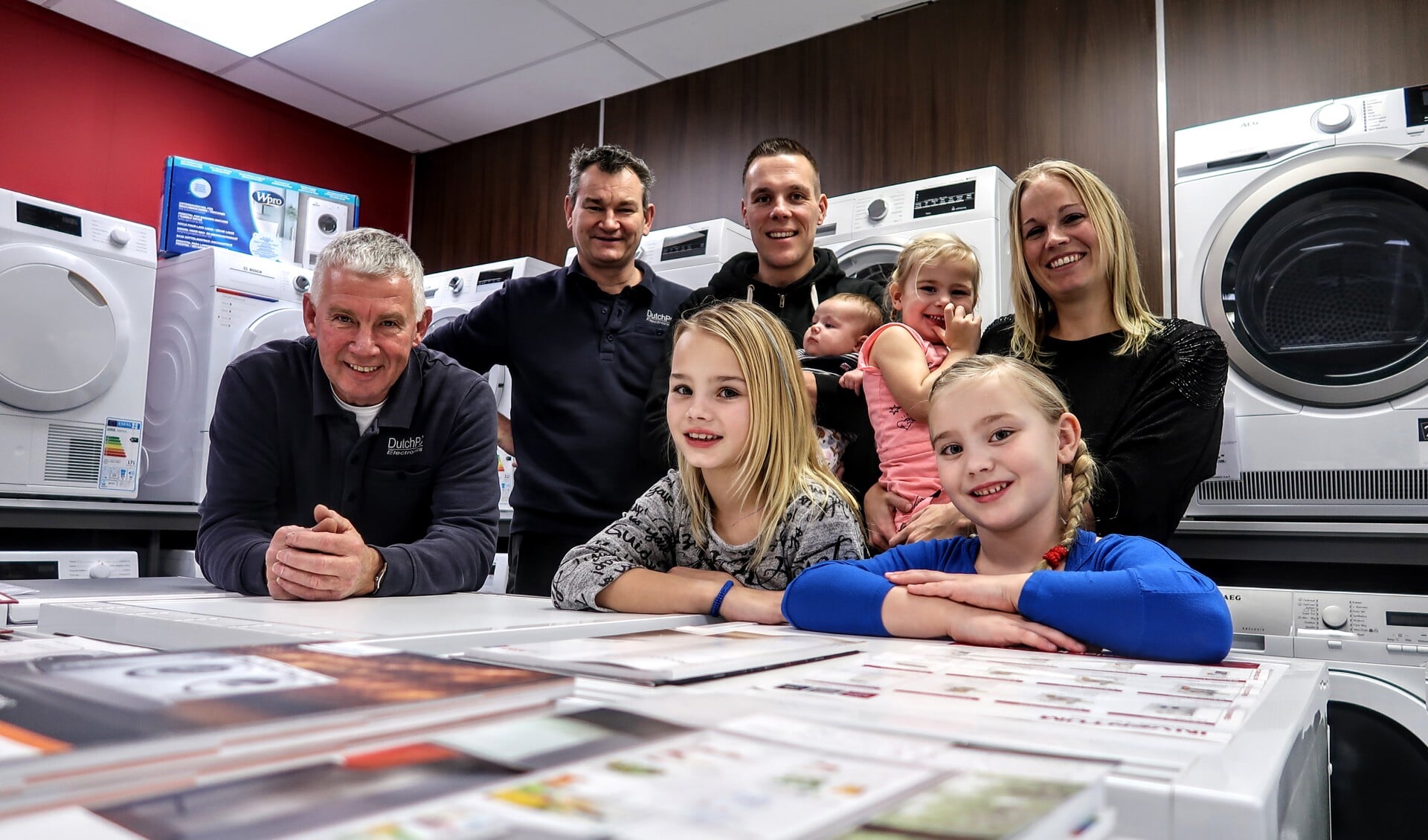 Ferdy Klein Brinke (derde van links, te midden van zijn gezin) is de nieuwe eigenaar van Dutch PC Electronics in Vorden. Hij heeft de zaak overgenomen van Bennie Mentink (meest links). Tussen hen in René Bosman. Foto: Luuk Stam