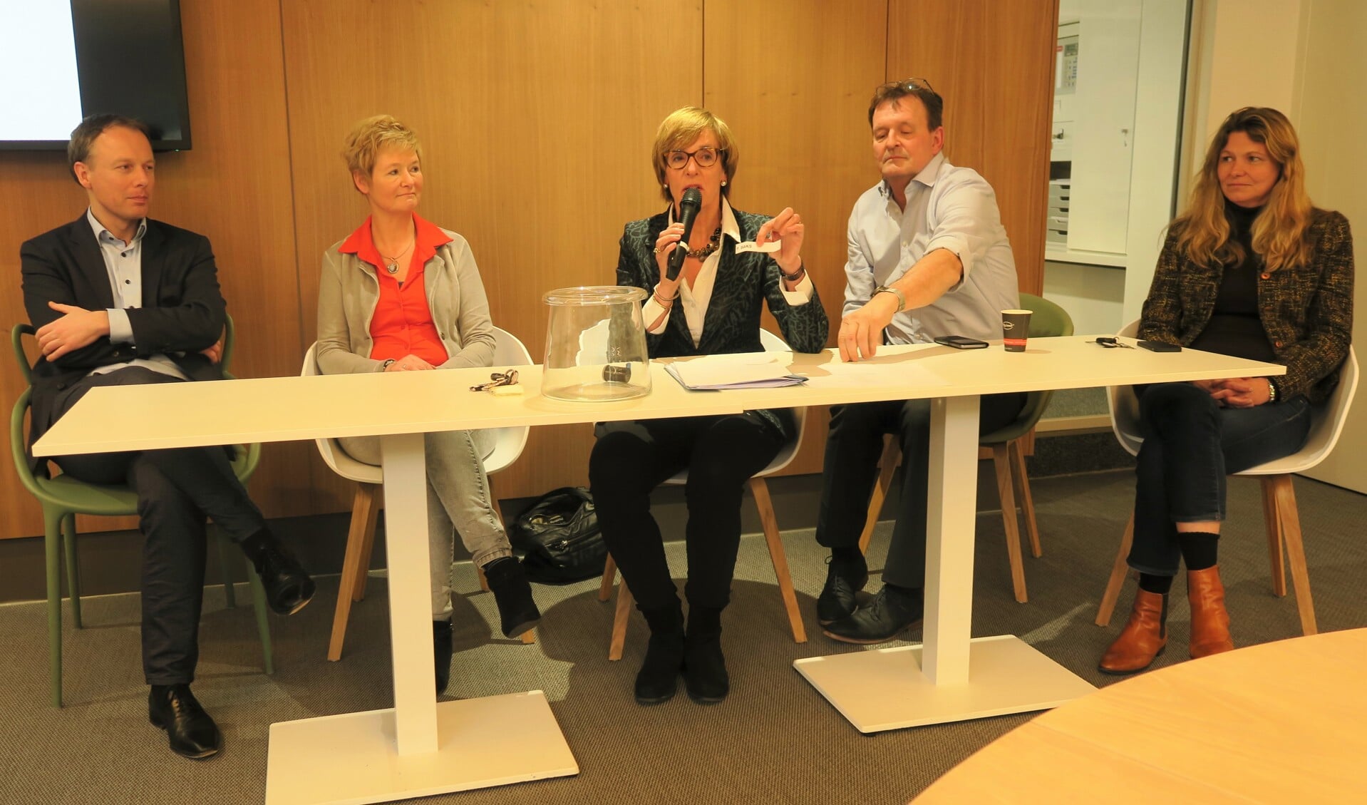 Annette Bronsvoort, als voorzitter van het centraal stembureau, trekt het lot dat niet Peter Baks maar Annelies Donderwinkel aanwijst als het tweede gekozen raadslid van de PvdA. Foto: Theo Huijskes